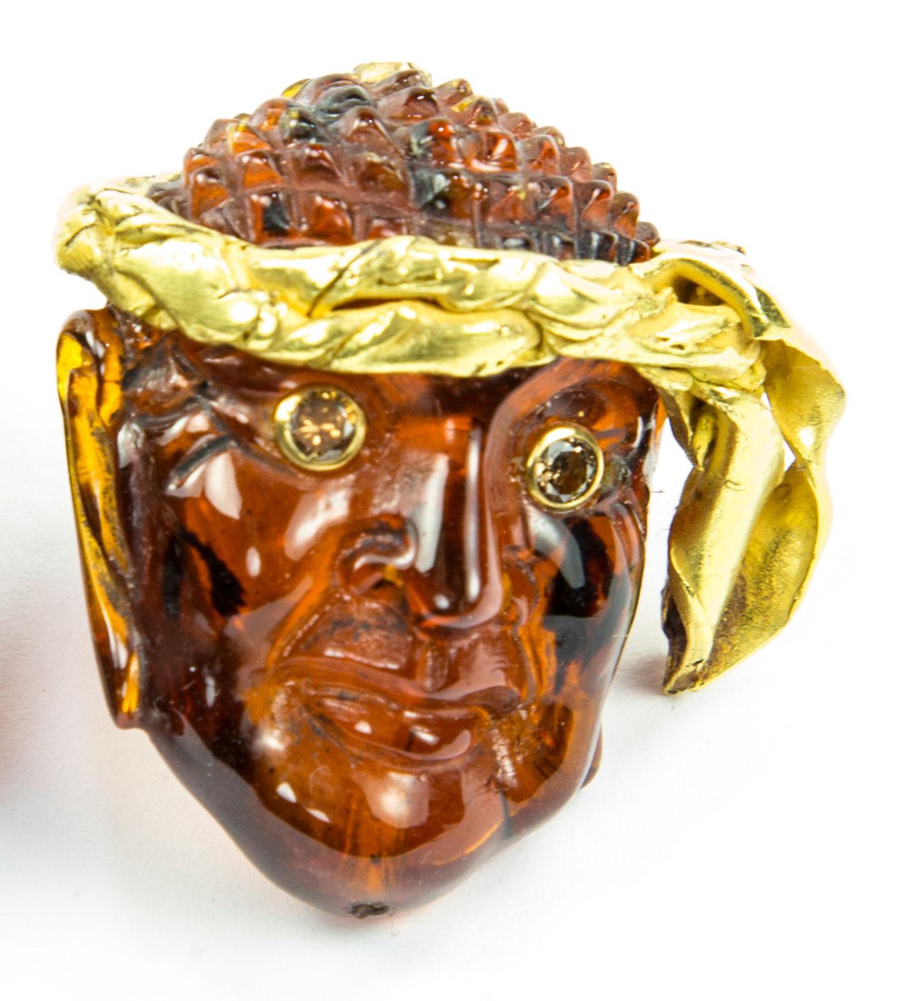 Sensational Finely detailed Antique Natural Amber Gemstone Figural Mask Pin featuring a Pirate with Champagne Diamond set eyes and wearing a 22 Karat Gold Hand crafted Headdress; Hand Carved in 3D with exquisite detail and attention for quality.