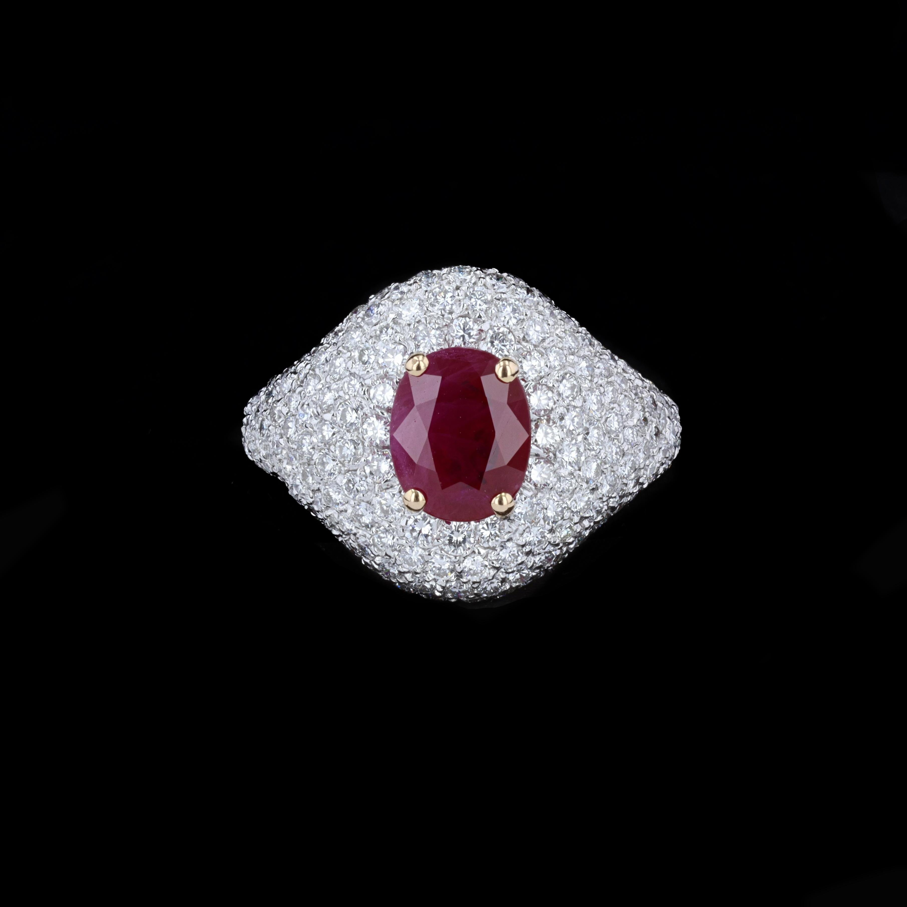An estate ruby and diamond ring crafted in 14k white and yellow gold. In the center is an oval-cut ruby of approximately 2.48 carats, framed in yellow gold prongs. Surrounding the center stone are nearly 250 round brilliant diamonds, set pave style