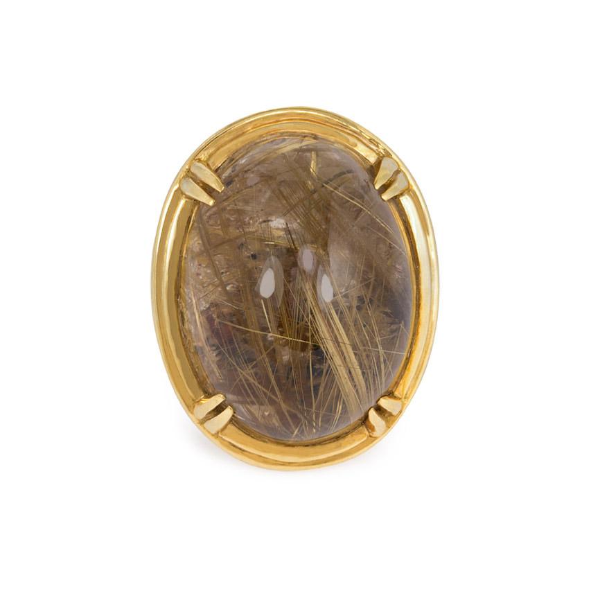An oversized rutilated quartz statement ring, the large oval smoky quartz claw-set within a gold bezel frame, completed by an openwork braided shank, in 18k.  France.  Top measures approximately 4.8cm x 3.7cm.

The silky stalks of needle-shaped