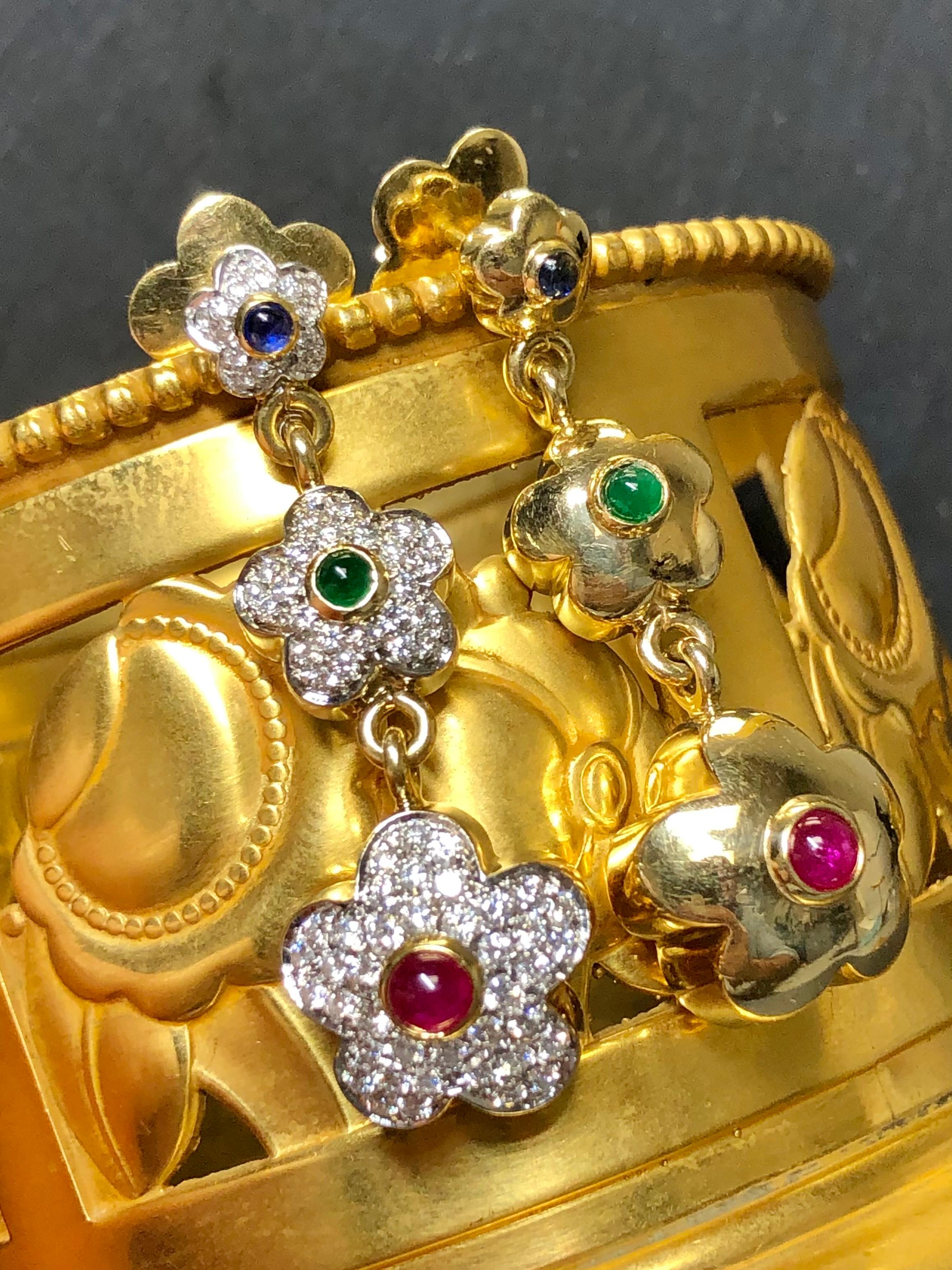 
A gorgeous pair of Pasquale Bruni earrings that just sing designer! They are crafted in 18K yellow gold and pave set with approximately 1.23cttw in F-G color Vs1 clarity round diamonds as well as cabochon rubies, emeralds and sapphires. Earrings