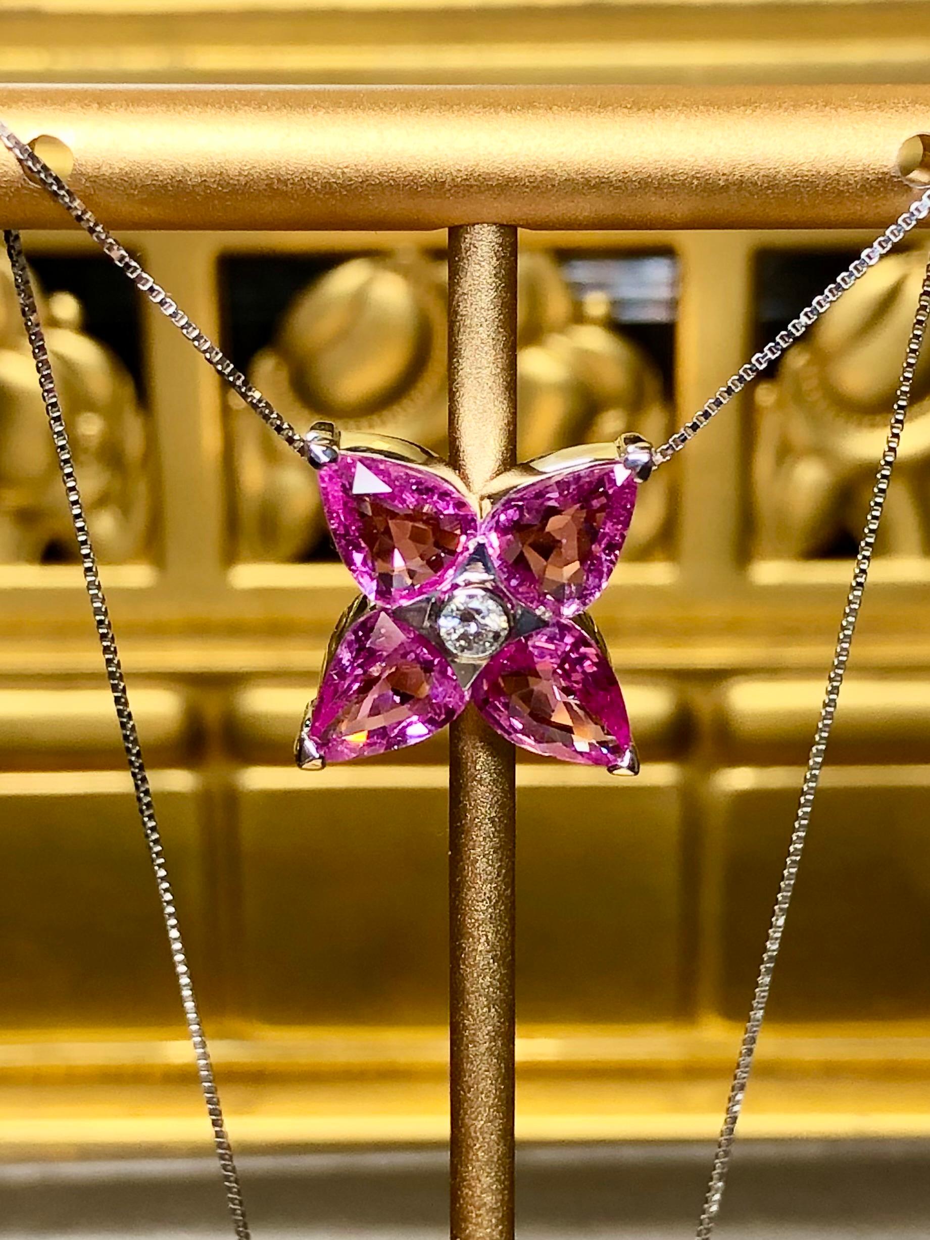 Ein schöner und lebendiger Anhänger, bestehend aus vier großen, natürlichen rosa Saphiren mit einem Gewicht von jeweils ca. 1,25ct, in deren Mitte ein runder Diamant mit der Reinheit G-H Vs von 0,10ct steht. Die Farbe ist phänomenal und wird durch