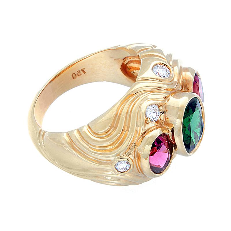 A colorful estate ring featuring approximately 4.00 carats of oval green tourmaline and deep pink tourmalines with diamond accents, all bezel set.  The diamonds run along a unique chiseled and carved 18K yellow gold setting.  

Currently ring size 6