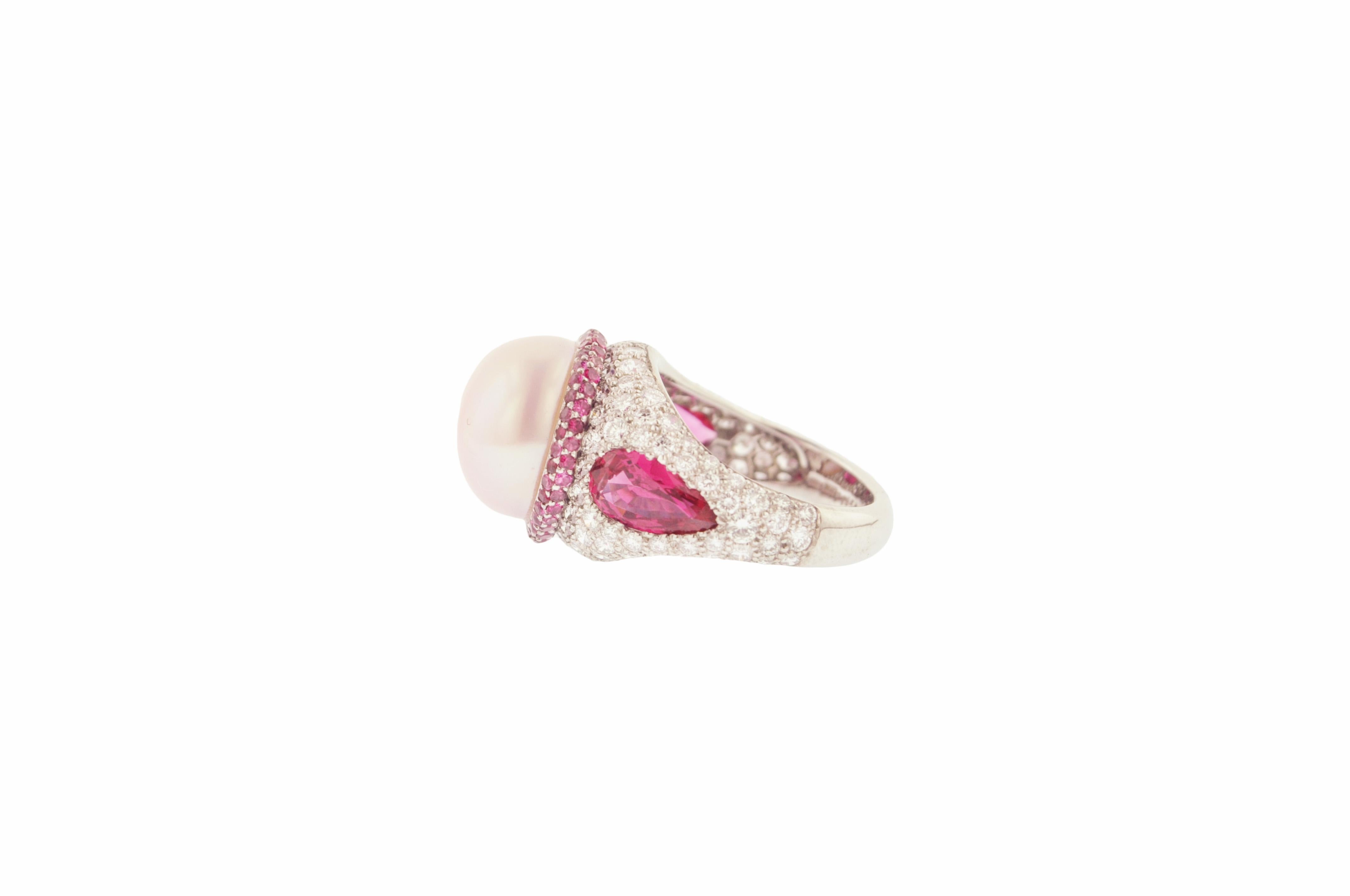Platinum estate cocktail ring featuring a pink pearl, pair of pear shaped pinkish red spinels and diamonds.

Ring size 6 3/4