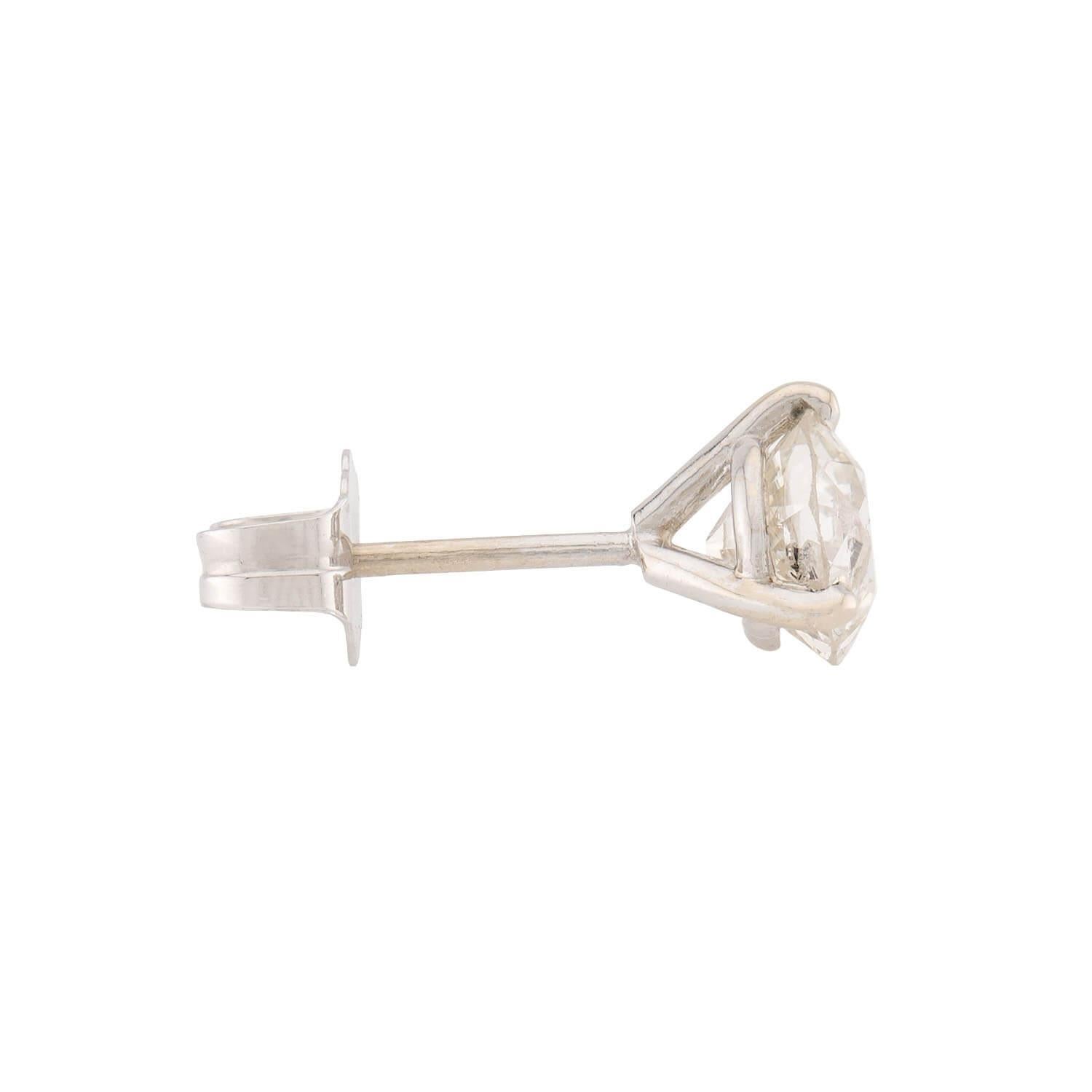 A gorgeous pair of Estate diamond stud earrings! Crafted in platinum and 14k white gold, each earring features an old European cut diamond held within a martini-setting. Together, the diamonds have an approximate total carat weight of 1.30ctw and