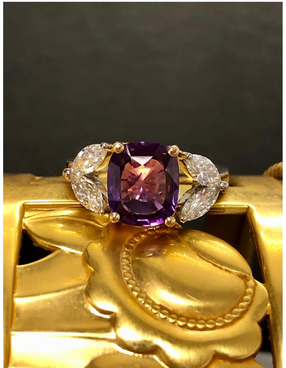 A beautifully made ring done in platinum and 18K centered by a 3.81ct natural cushion cut “no heat” deep purple sapphire (GIA report included in the sale) flanked by 4 marquise diamonds being G-H color and Vs1-Vs2 clarity with a total approximate