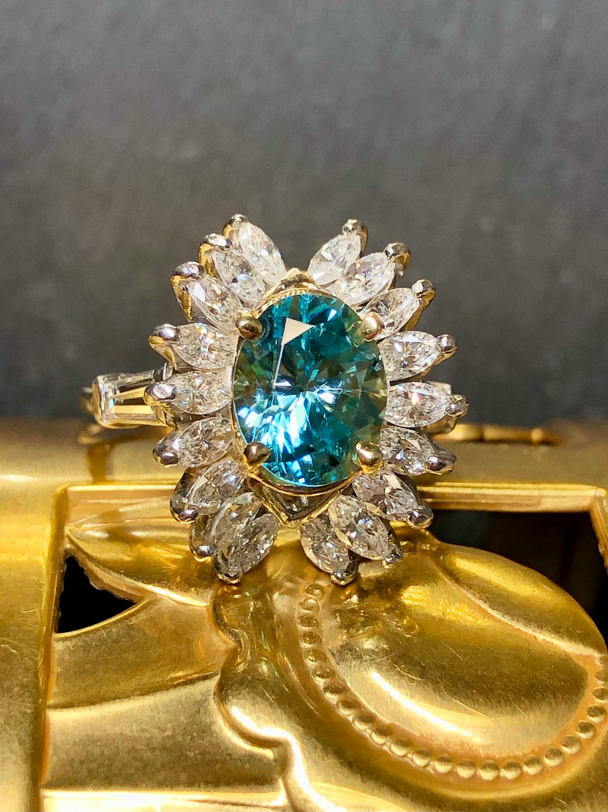 A beautiful and uniquely designed cocktail Ring done in platinum centered by an oval shape approximately 3.83ct natural zircon. The color is an absolutely gorgeous aqua with green undertones… very bright material. Flanking the center stones are