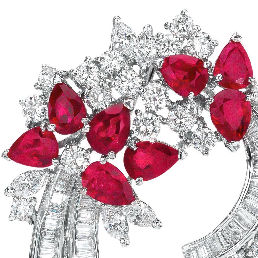 A curved spray with clusters of round brilliant and marquise-cut diamonds, with eight pear-shaped rubies on a curved double row of diamond baguettes;  can be worn as a brooch or a pendant. set in platinum.
8 Pear Shaped Rubies = 8.74 carats total
20