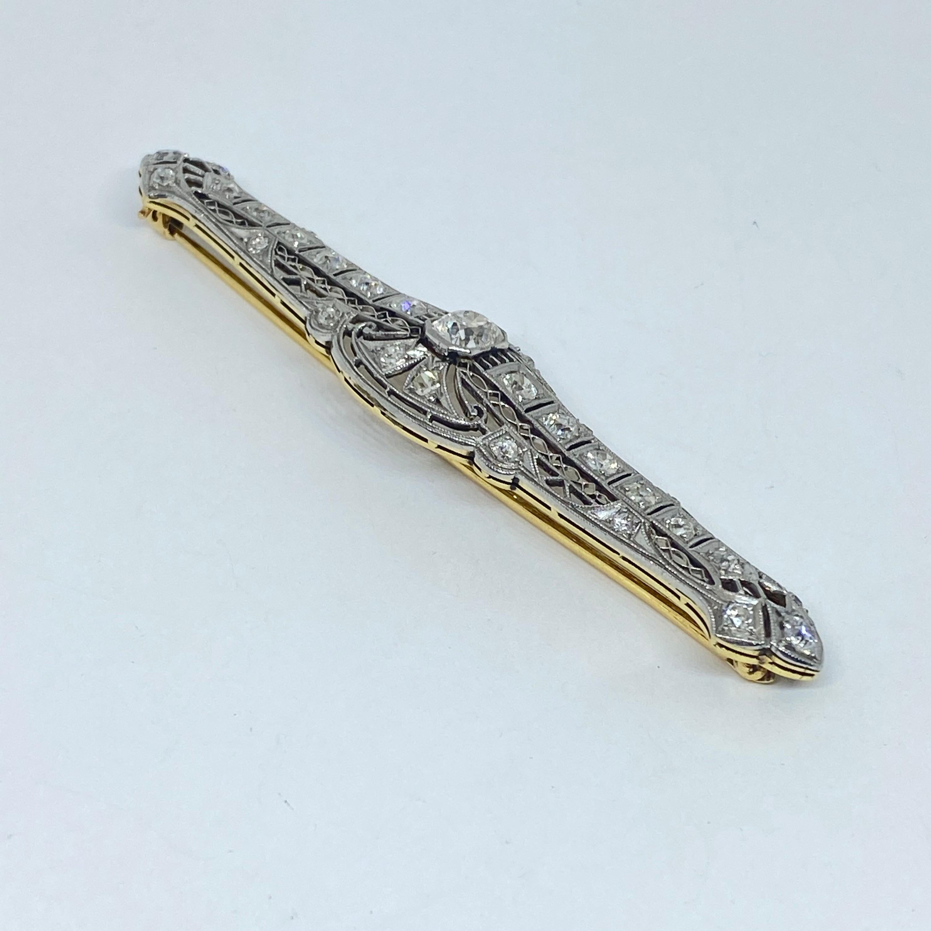 This brooch is fashioned from Platinum and 14K yellow gold. It is set with old European and old mine cut diamonds. The diamonds are set in platinum and the back plate and pin closure is 14K yellow gold. The center diamond is a modified old mine cut