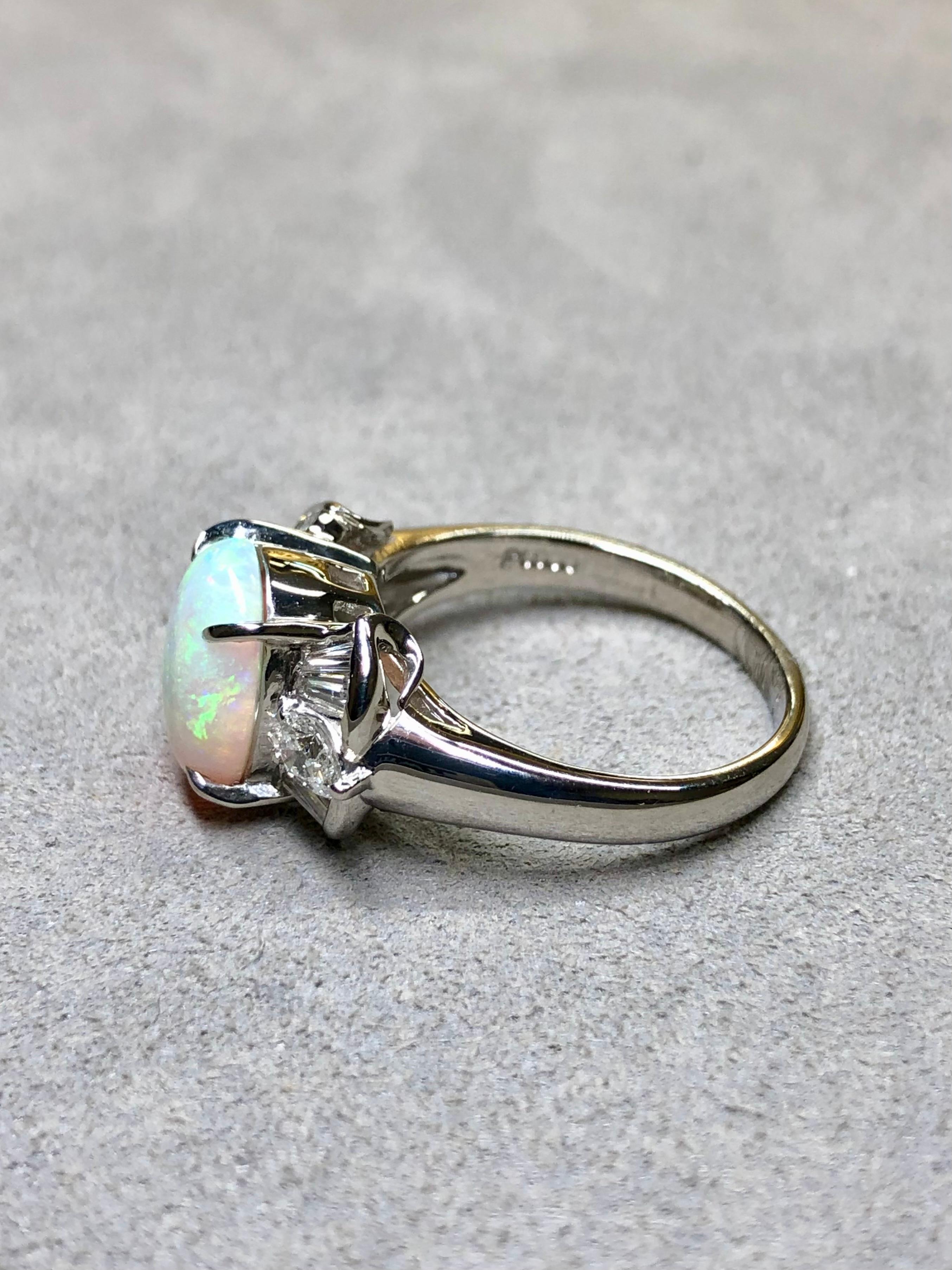 Ein eleganter Cocktailring, in dessen Mittelpunkt ein wunderschöner und lebendiger australischer Opal mit einem Gewicht von 2,20 ct steht, umgeben von Diamanten mit einem Gewicht von 0,60 ct in der Farbe G-H und der Reinheit Vs1-2 in Form von