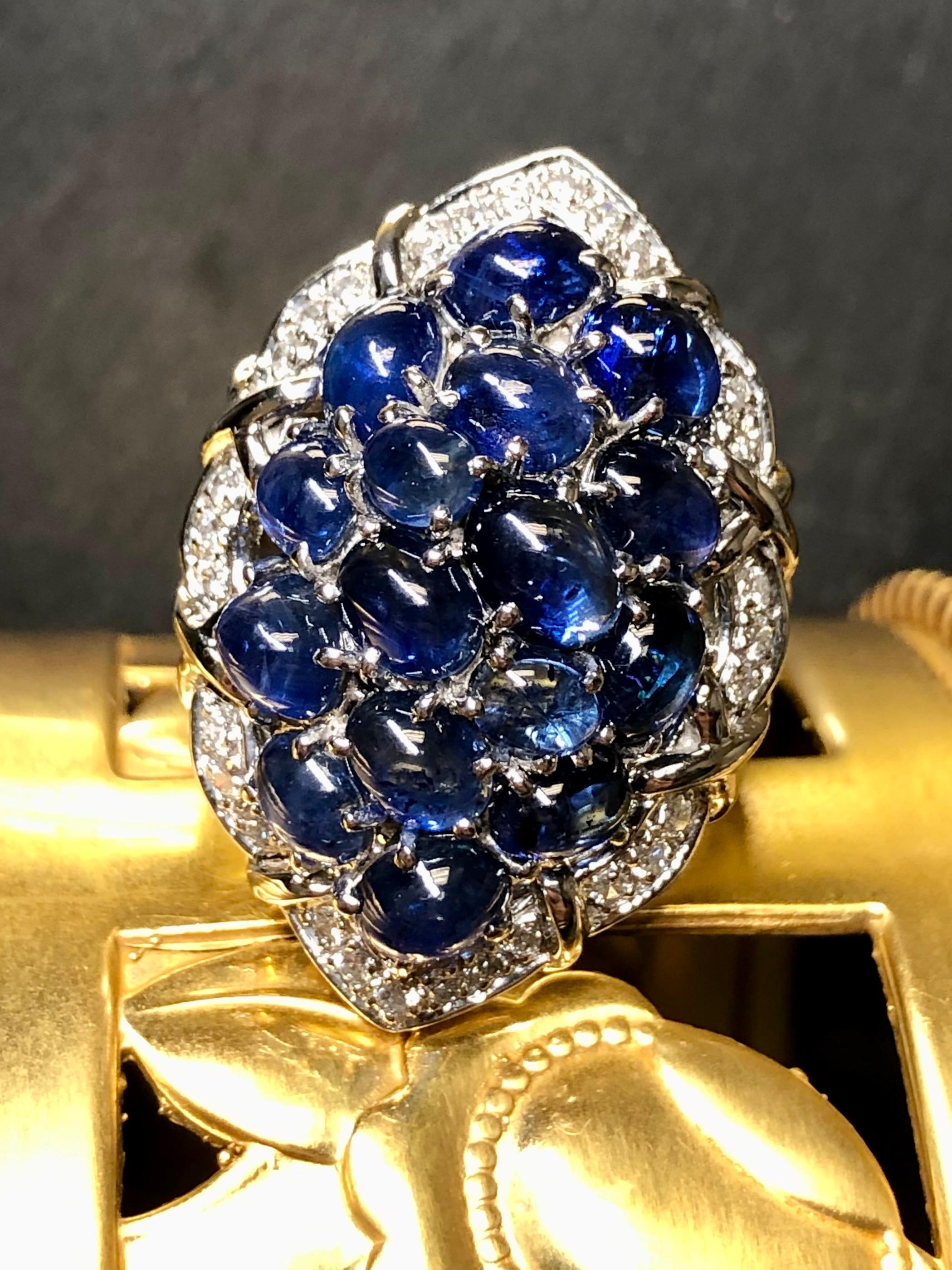 An incredibly colorful cocktail ring crafted in platinum and set with approximately 11.50cttw in vibrant royal blues cabochon sapphires surrounded by approximately .50cttw in G-H color Vs1-2 clarity round diamonds. A gorgeously made and substantial