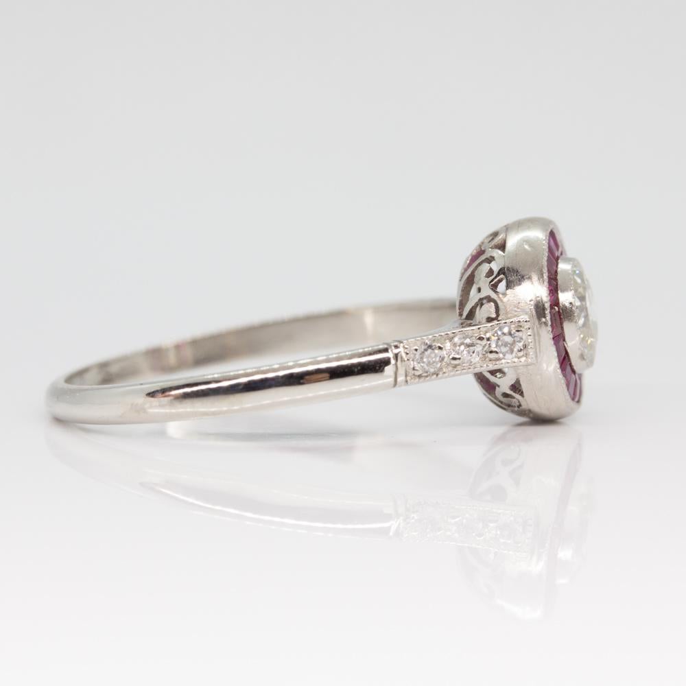 Composition: Platinum
Stones:
• 1 Old mine cut diamond H-VS2 0.35ctw
• 16 natural French cut rubies 0.50ctw
• 6 old mine cut diamonds H-VS2 0.06ctw
Ring size: 7 
Ring face:  8mm
Rise above finger: 5mm.¬
Total weight:  3grams – 2dwt 
Appraisal