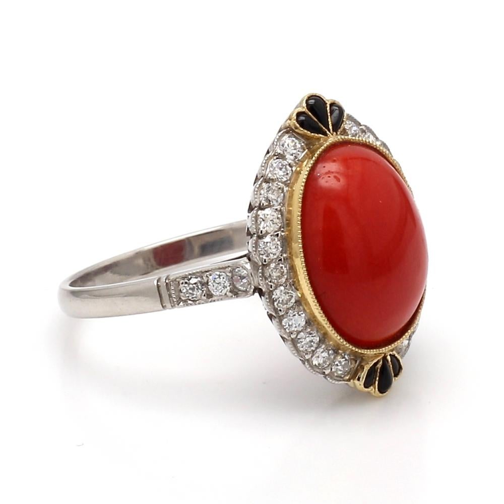 Platinum and 18K yellow gold ring. Center stone is one (1) oval, cabochon cut coral measuring approximately 12.5mm x 10mm. Ring is set with twenty-eight (28) round brilliant cut diamonds weighing approximately 0.36ctw and six (6) fancy cut, cabochon