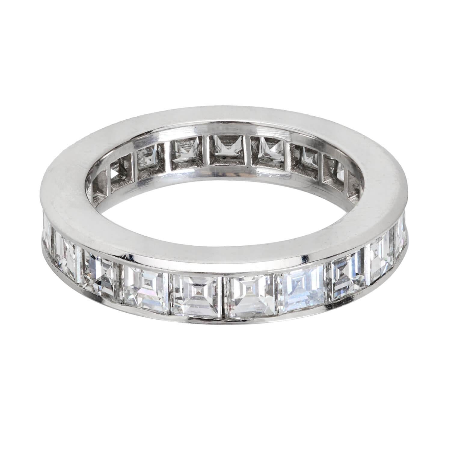 A stunning diamond eternity band! This simple yet classic platinum ring displays a row of emerald cut diamonds, which rest within channel settings. The diamonds carry throughout the entirety of the band, and have an approximate total carat weight of