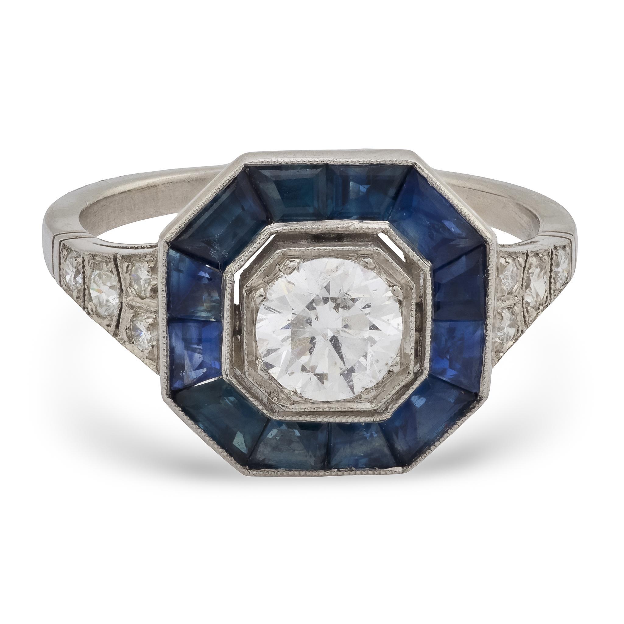 Uno splendido anello di fidanzamento con diamanti e zaffiri! Realizzato in elegante platino, questo anello presenta un diamante centrale di 0,60 carati con taglio vecchio europeo, incastonato a perline. Il diamante ha un colore I e una purezza SI1.