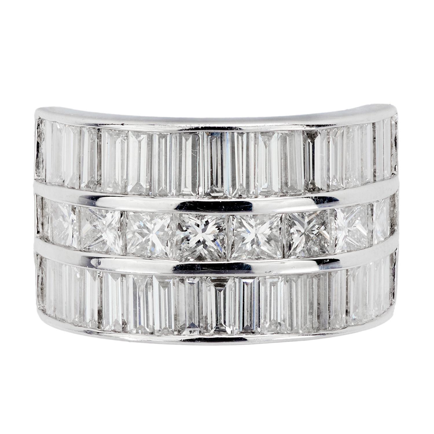 A fabulous and bold ring! Crafted in platinum, this ring features a central row of princess cut diamonds, which are channel set and have an approximate total carat weight of .90ctw. The princess cut diamonds are bordered on both the top and bottom