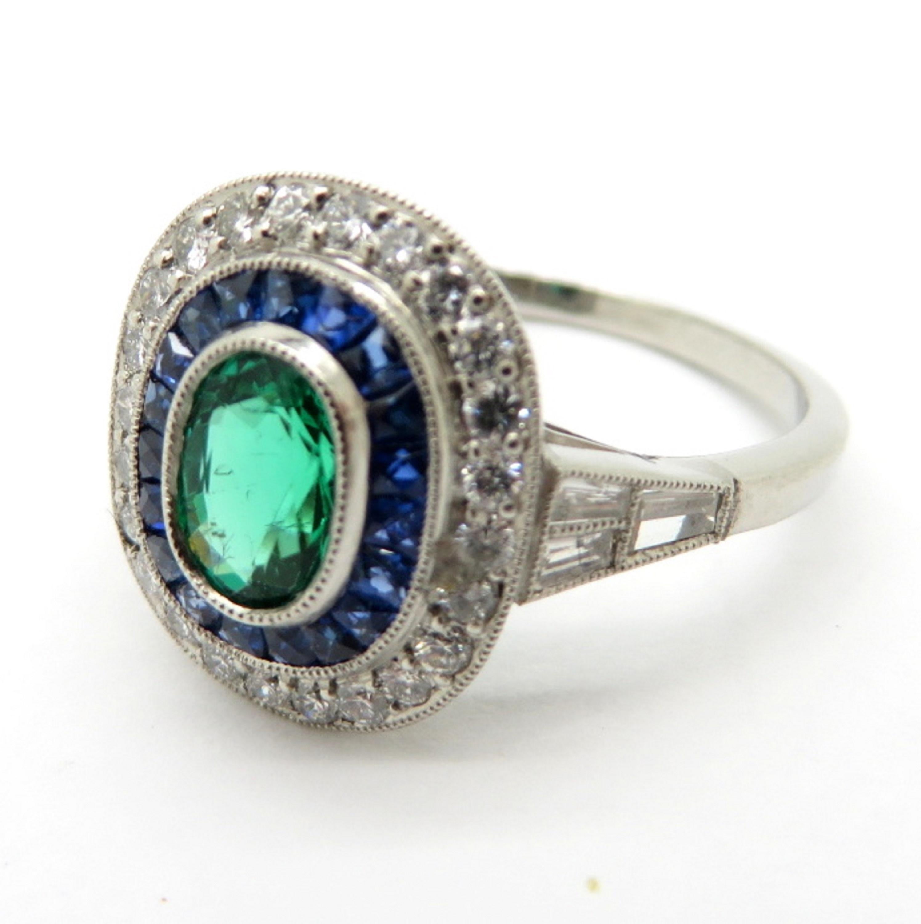 Centering 1 Oval fine quality natural Emerald, milgrain bezel set, weighing approximately 0.62 carats.
Featuring 24 Round Brilliant Cut diamonds, weighing 0.28 carats, having H-I Color Grade and SI1 Clarity Grade.  Accented by 6 Tapered Baguette