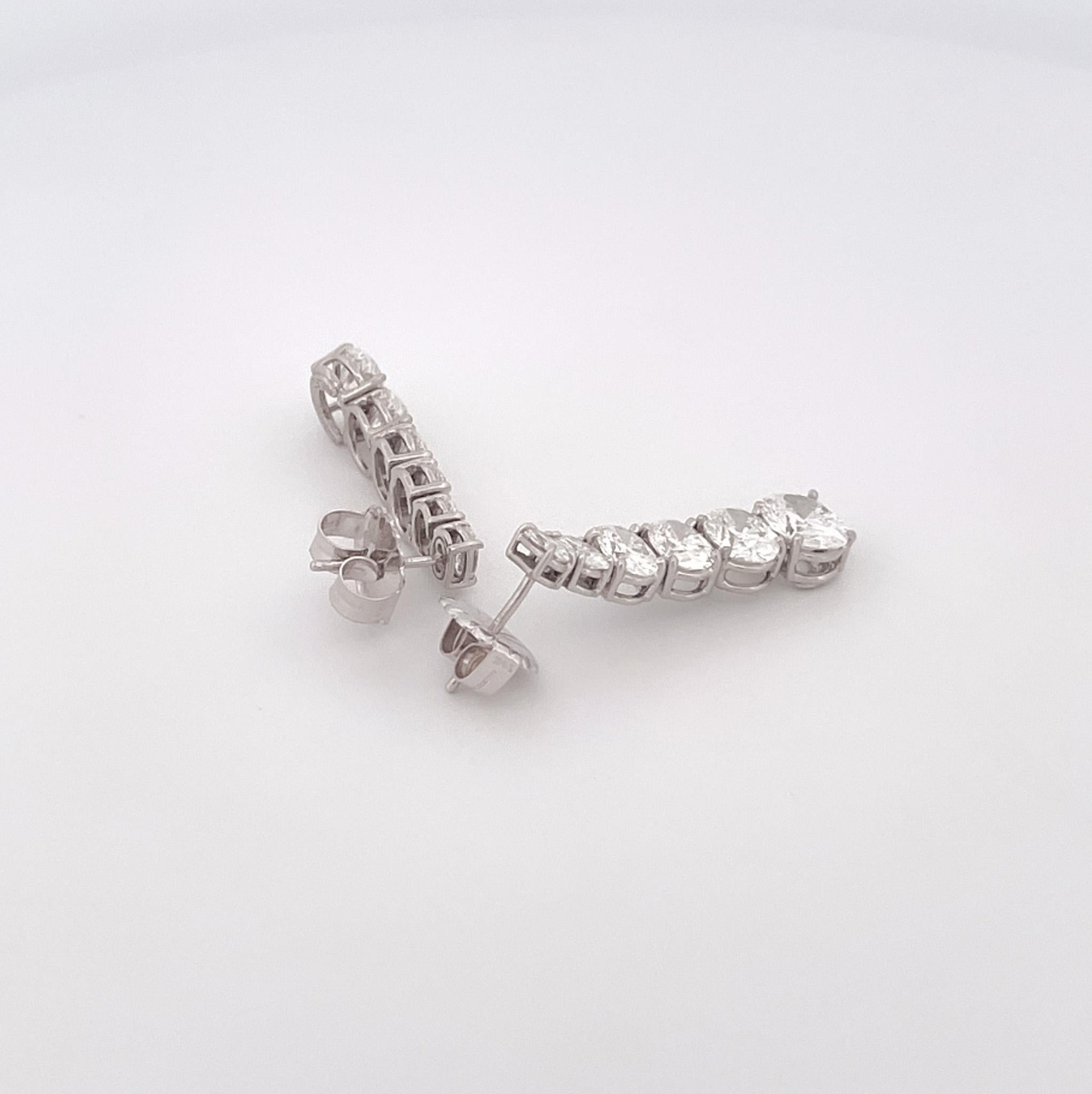 From the Eiseman Estate Jewelry Collection, platinum diamond drop earrings featuring 12 graduated oval diamonds with a combined total weight of 8.15 carats, with E-F color and SI clarity. These earrings are crafted with 1.25 inch drops on each ear