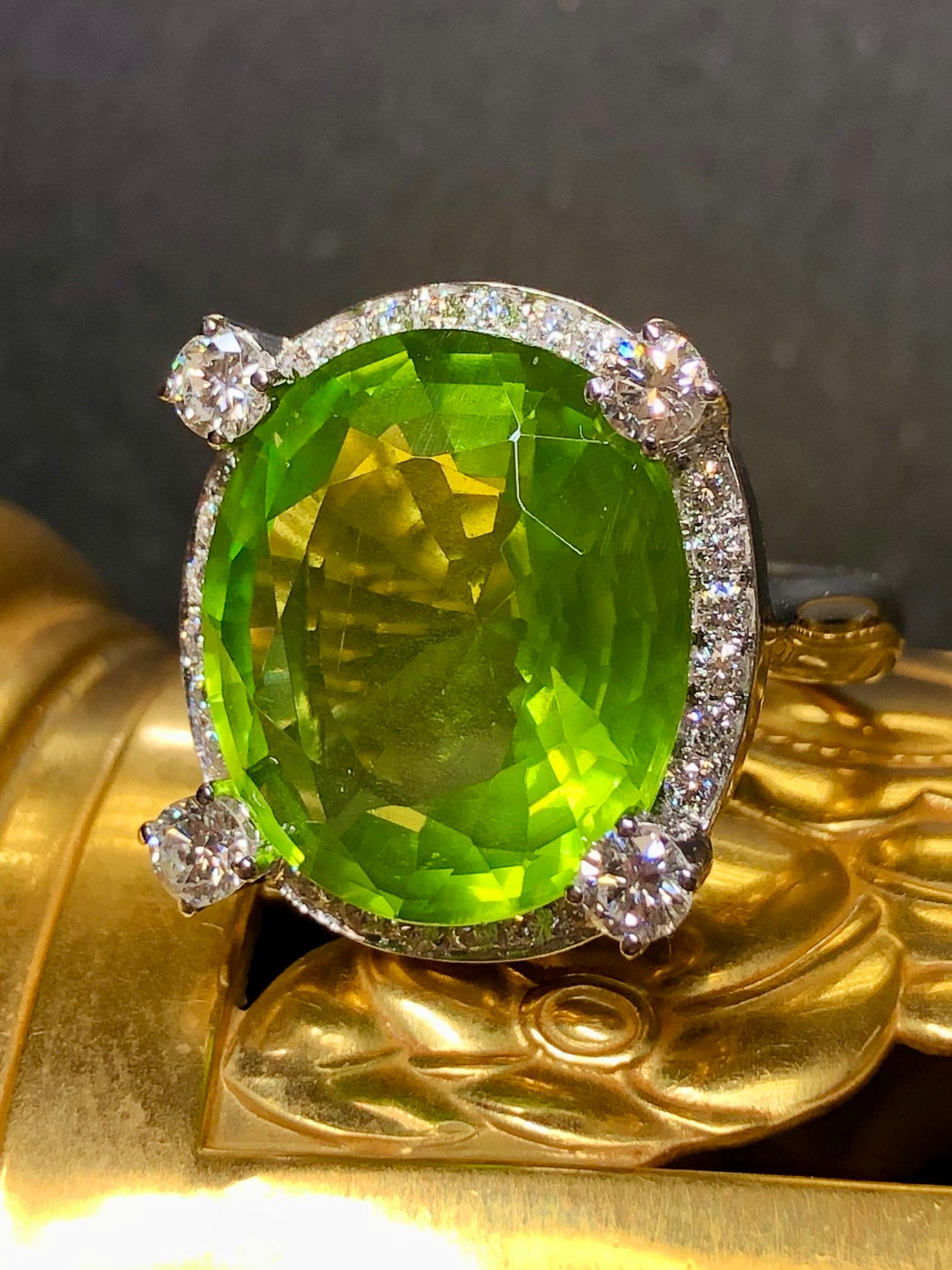 This absolutely spectacular cocktail ring is centered by a very impressive 18.53ct natural, bright electric green peridot surrounded by 1.08cttw in G-H color Vs1-2 clarity round diamonds. All stone weights are stamped inside of the