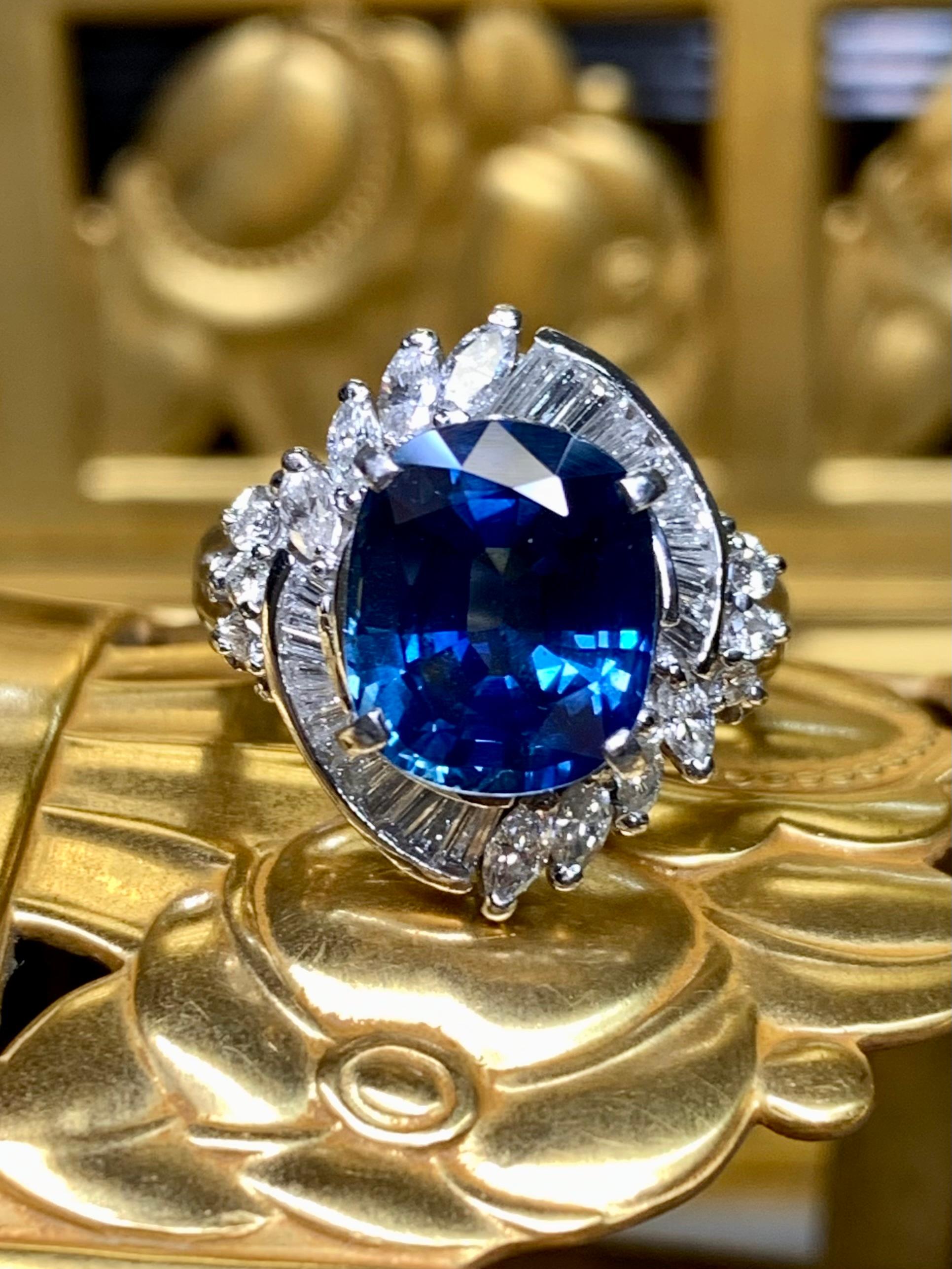 
A traditional style cocktail ring crafted in platinum and centered by a beautiful bright blue oval cut natural sapphire (heat only) weighing 4.17ct (10.22mm x 8.44mm x 5.40mm) surrounded by .71ctw in both marquise and baguette cut diamonds