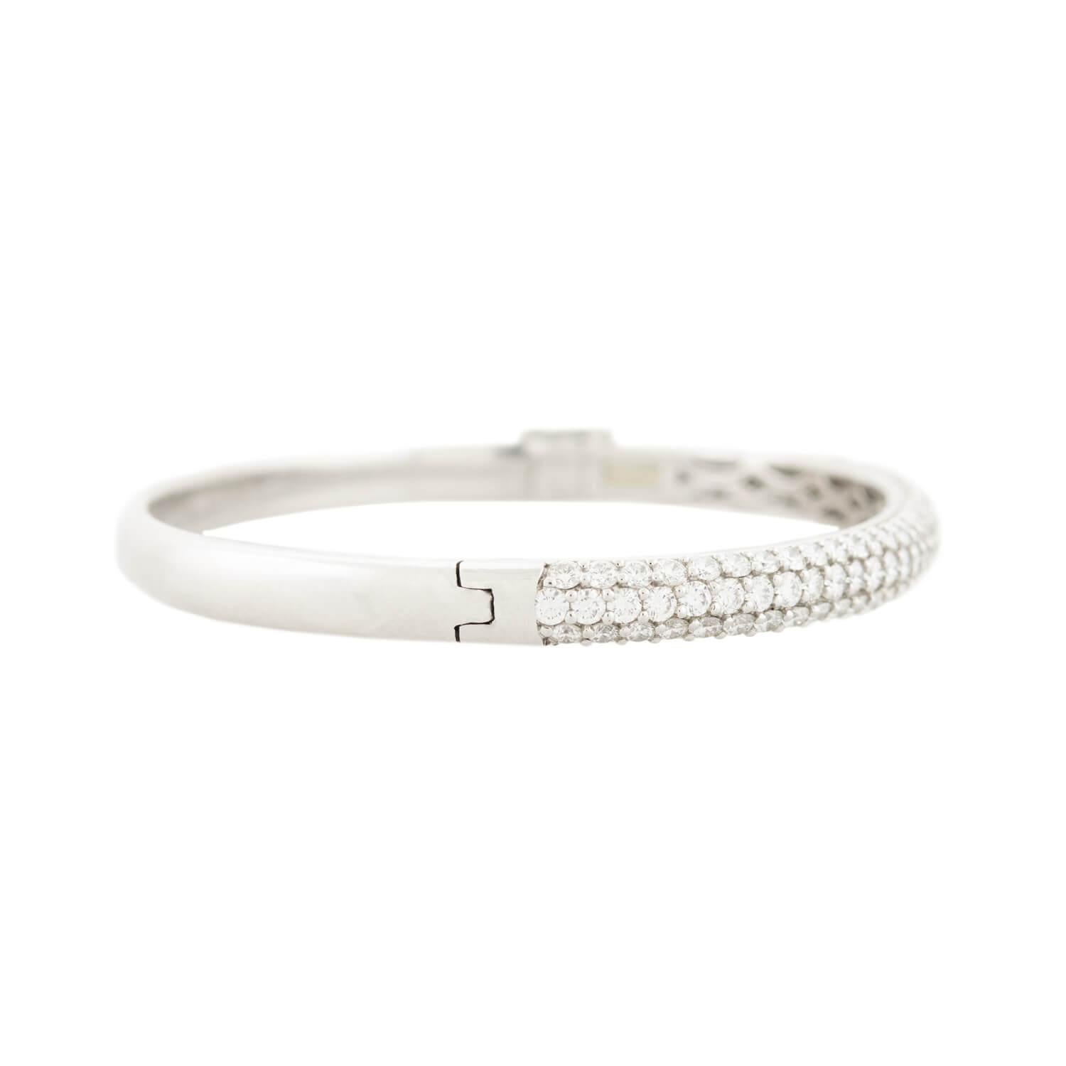 ¡Una magnífica pulsera brazalete con pavé de diamantes! Esta hermosa pieza está elaborada en platino y tiene tres filas de diamantes engastados en pavé (pavimento en francés). Los diamantes de talla completa, que adornan la mitad del brazalete,
