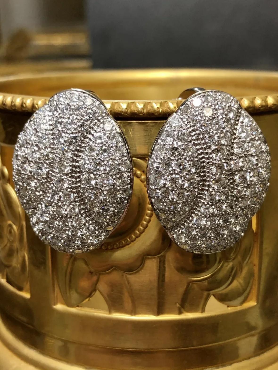 A beautifully crafted pair of large Huggie earrings done in platinum and pave set with approximately 5.50cttw in G-H color and Vs1+ clarity round diamonds. These earrings have omega backs with swing posts so that they can be worn either