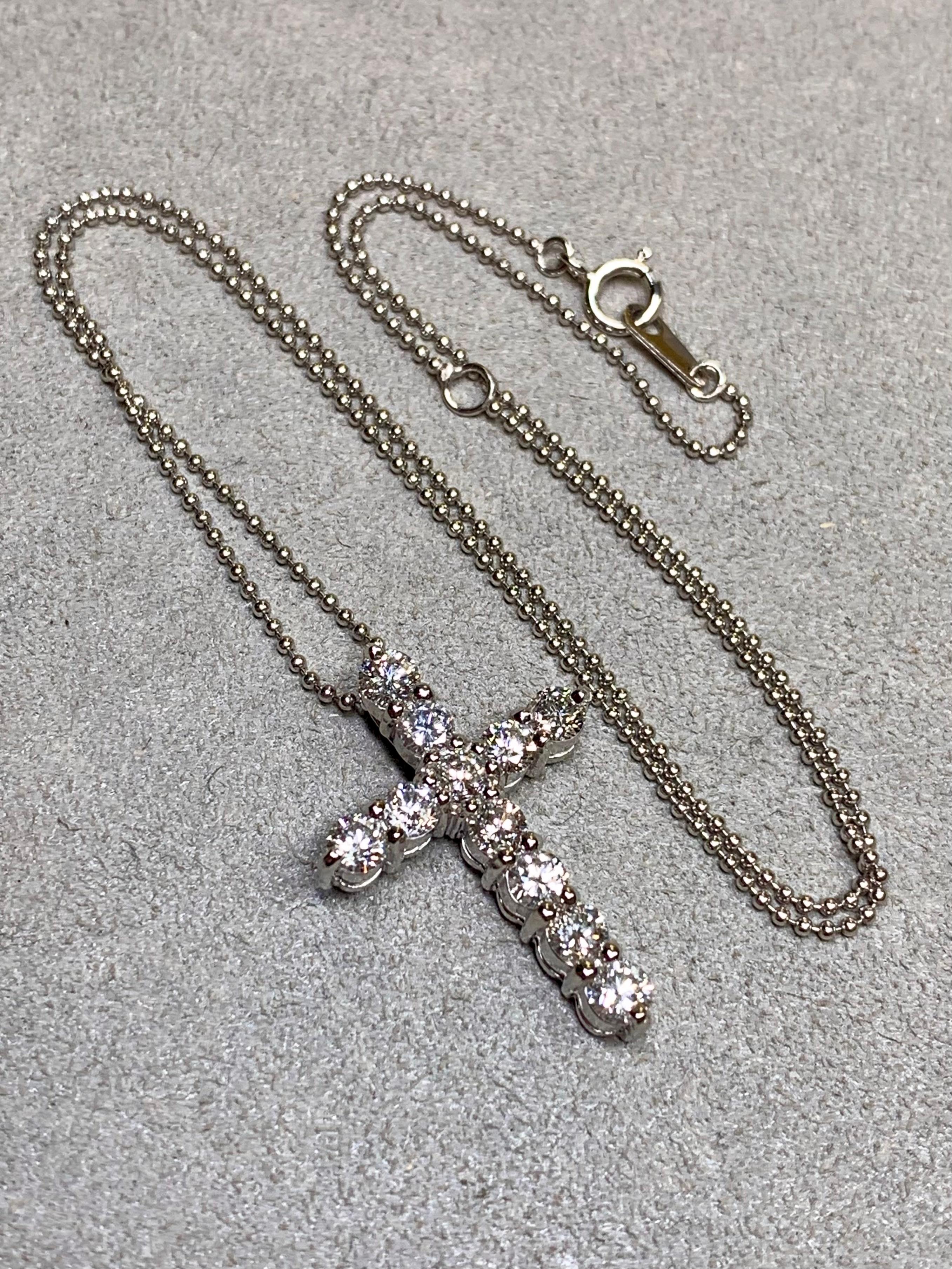 A refined and timeless estate cross pendant crafted in platinum, elegantly prong-set with 1.50 carats total weight of round brilliant-cut diamonds averaging approximately 0.13 carats each. The diamonds display fine G–H color and VS2–SI1 clarity,