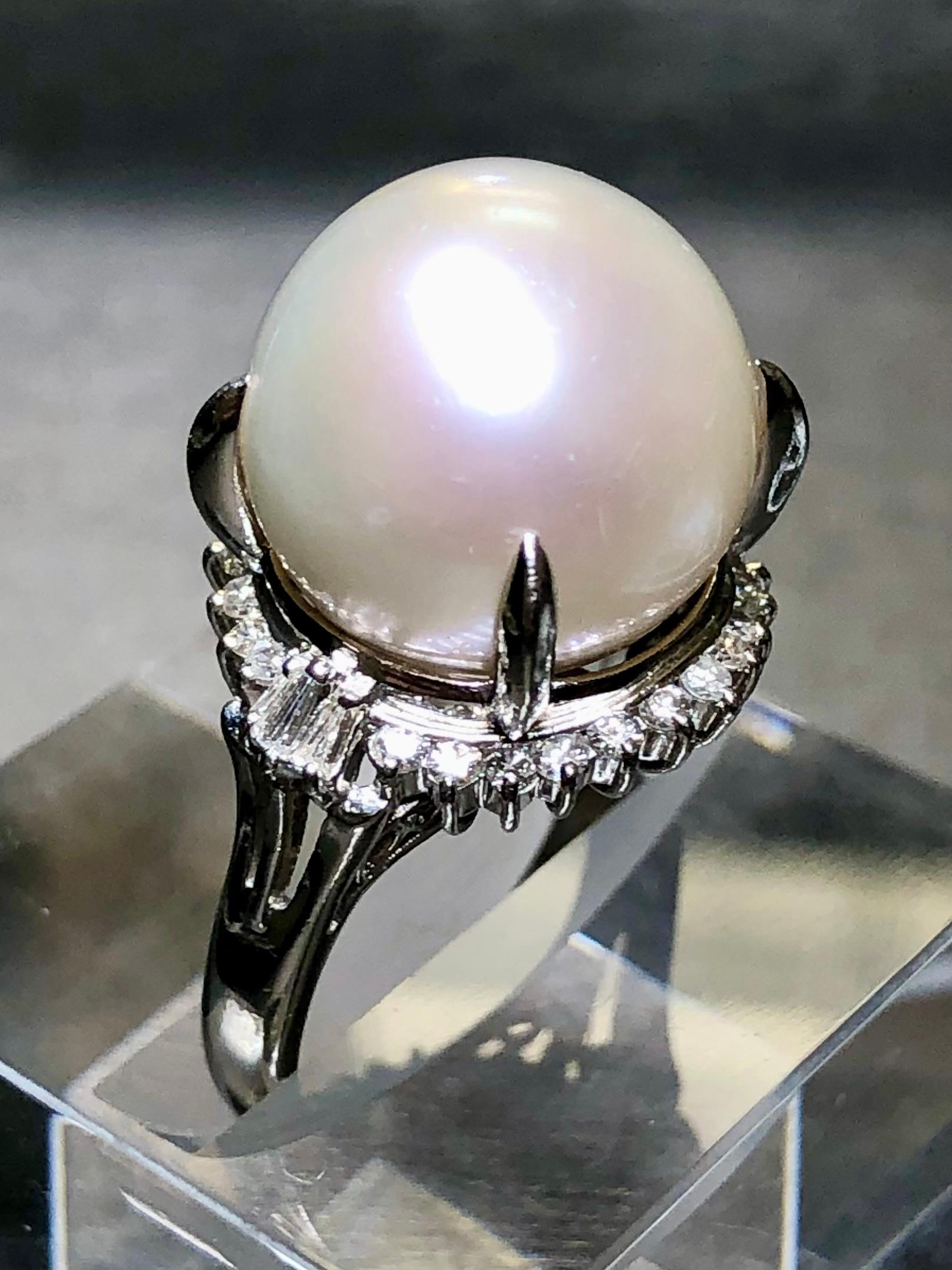 A classically designed cocktail ring done in platinum and centered by a genuinely beautiful South Sea pearl with a lovely even luster and color measuring 14.50mm. Surrounding the central pearl is .46cttw in round and baguette diamonds ranging G-I in