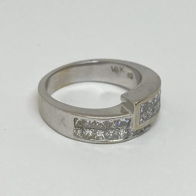 Ehemaliger Ring aus 18 Karat Weißgold. Besetzt mit zwei Reihen unsichtbar gefasster Diamanten im Prinzessschliff im Bypass-Design. Der Ring misst 8 mm an der breitesten Stelle und verjüngt sich zu einem 4 mm langen Schaft. Die Diamanten haben die