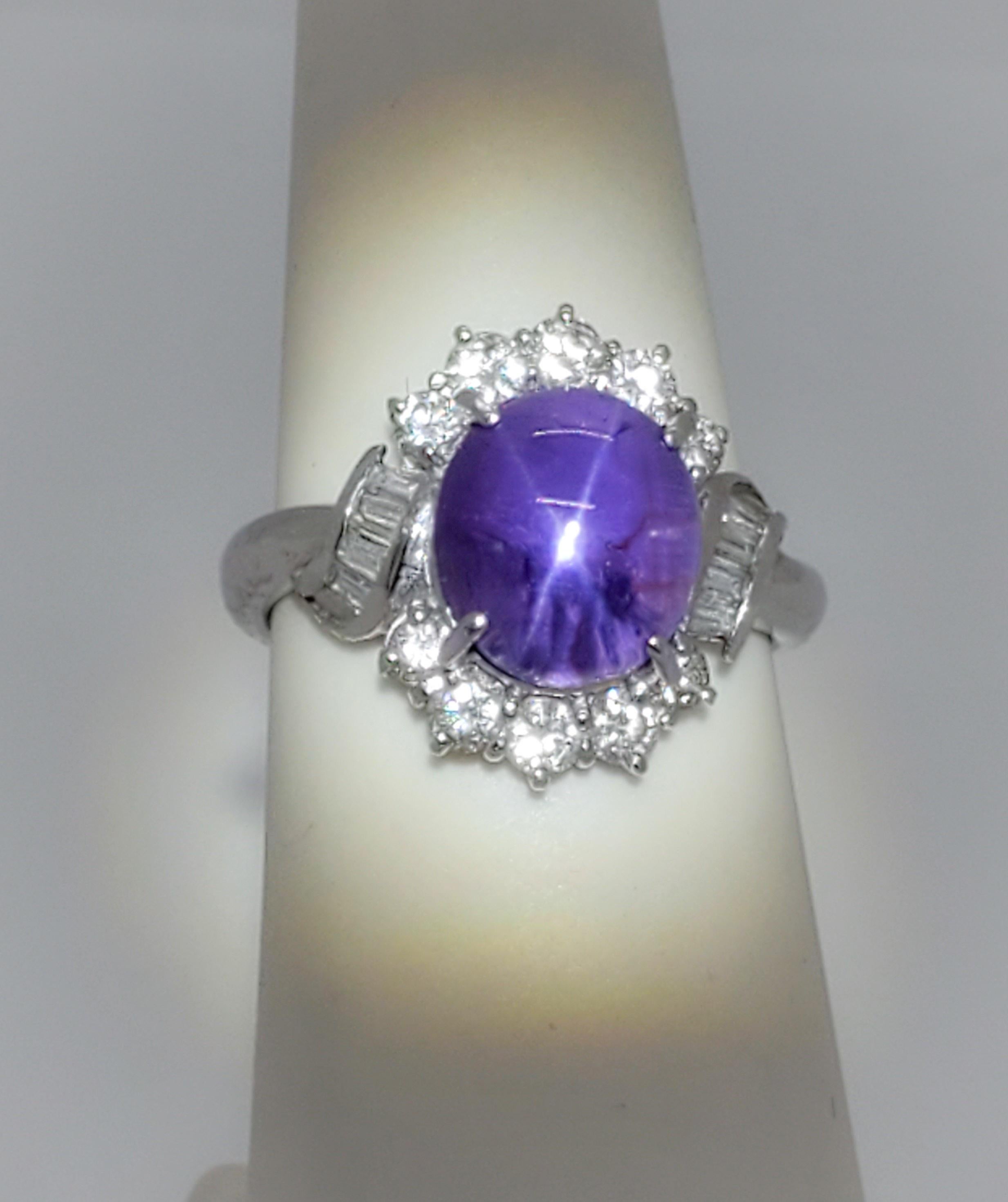 Wunderschöner violetter Sternsaphir mit einem markanten 6-zackigen Stern.  Der Sternsaphir wiegt 5,11 ct. mit 0,67 ct. weißen runden und baguettierten Diamanten guter Qualität.  Handgefertigt in Platin.  Die Ringgröße ist 5,5.