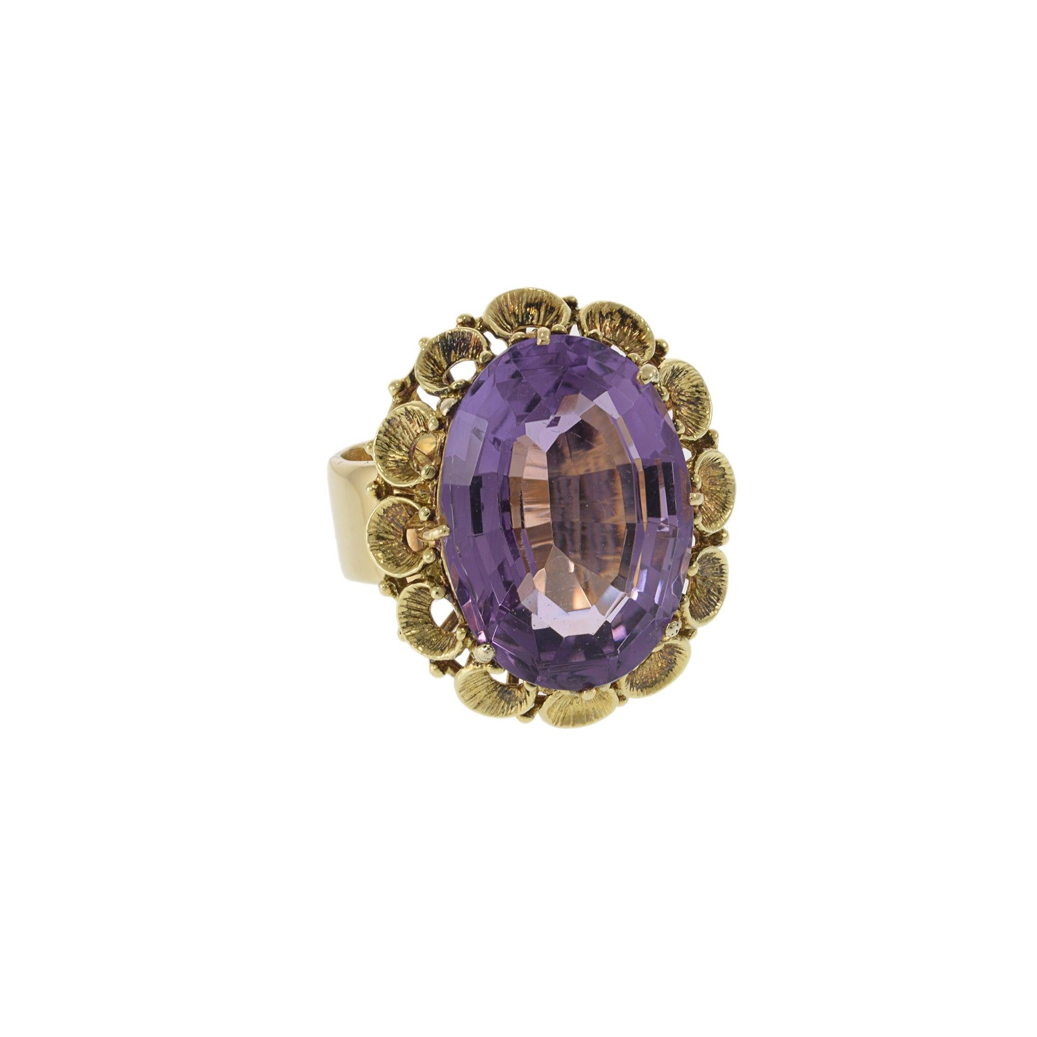 This stunning estate retro era ring features a large 19.40CT amethyst set in warm 14KT yellow gold. The gemstone's rich purple hue is a perfect match for the gold setting, creating a bold yet elegant contrast. The ring's classic design is both