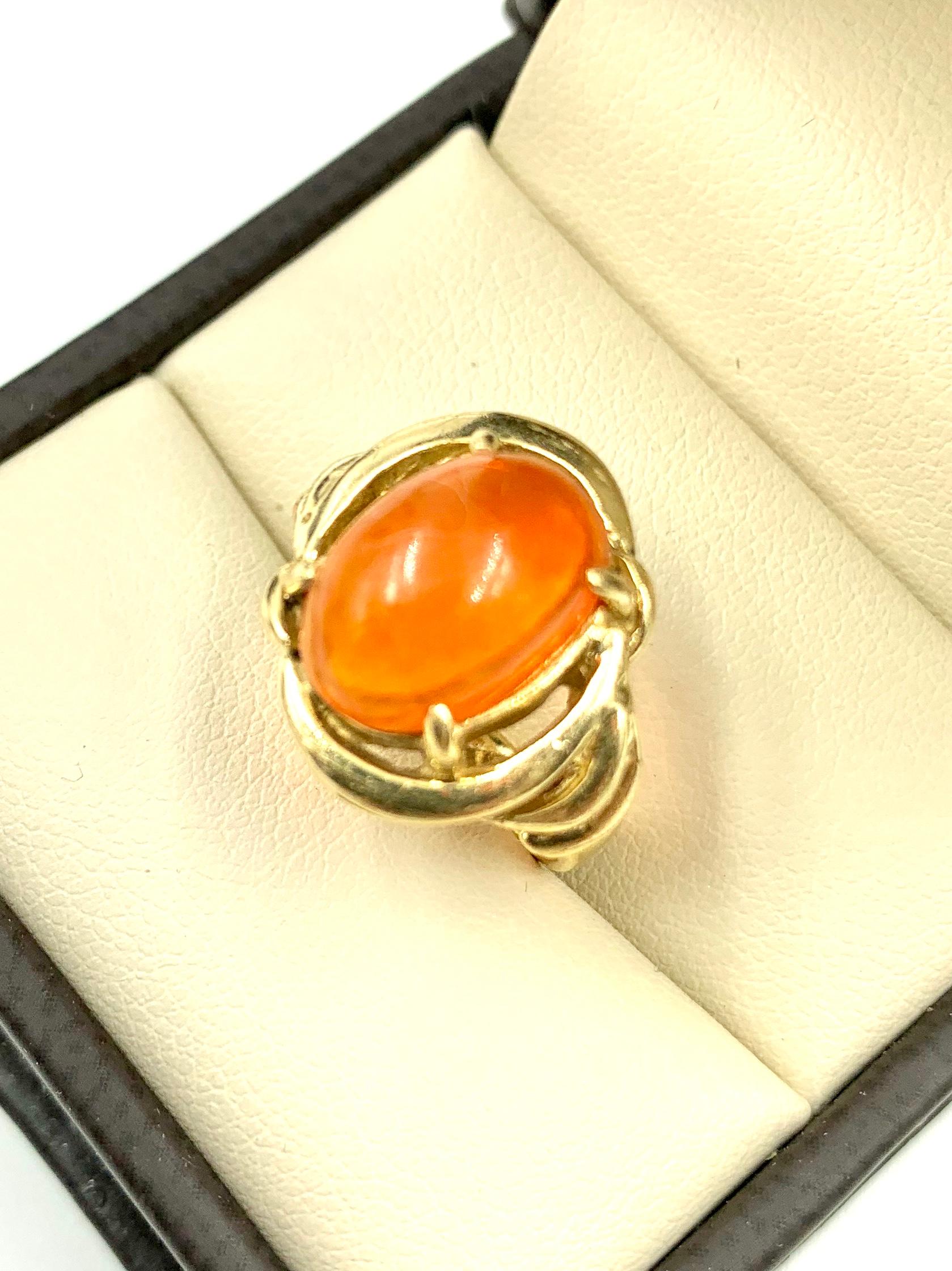 Beautiful vibrant orange oval cabochon fire opal 14K yellow gold ring.
The unusual gold swirl design of this ring complements the natural fiery swirl inclusions of the opal gemstone. 
Opals are among the most fascinating and desirable gemstones. The