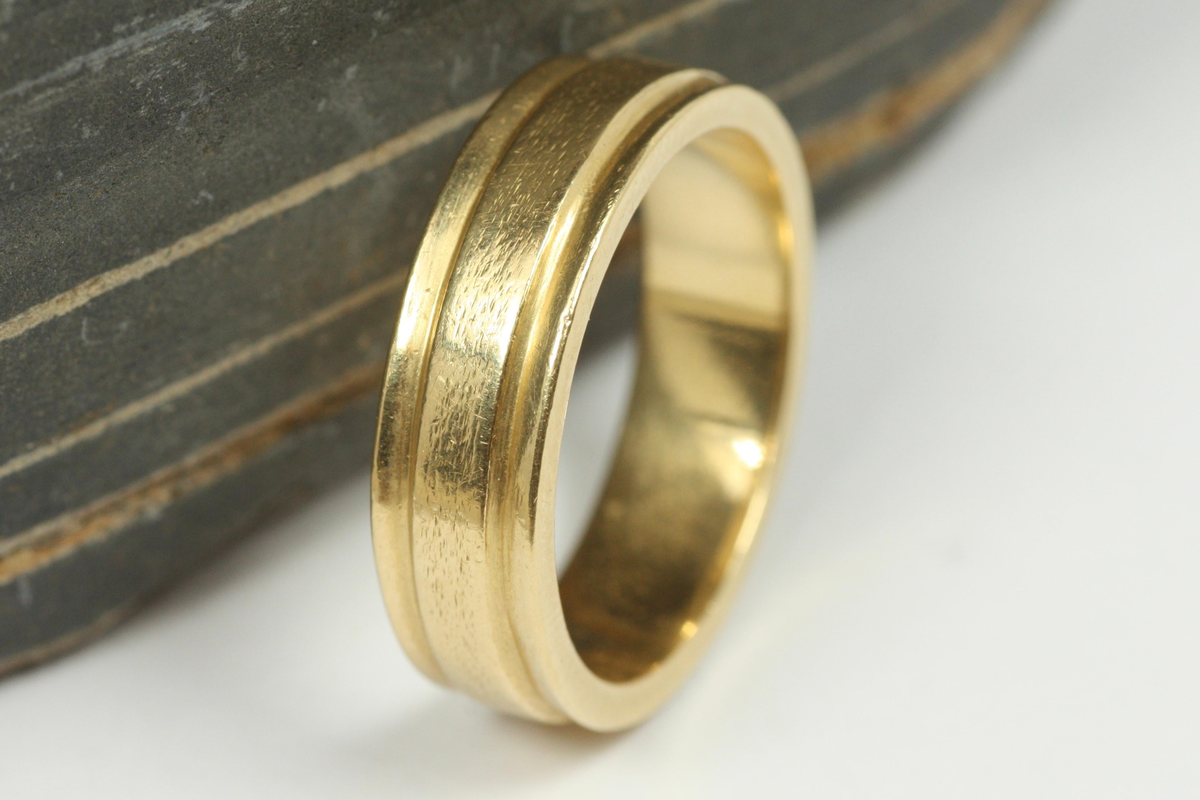 This modern estate 18K yellow gold triple-ridged wedding band is one of many unique finds from our estate wedding ring collection at Bracken Jewelers in Santa Monica, California. The stepped-edge design on each side presents like an inverted beveled