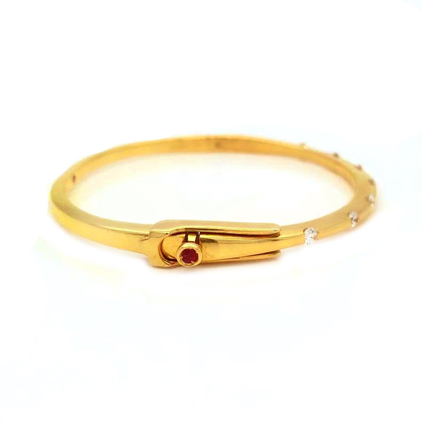 An 18K yellow gold lady's hinged bangle bracelet, Roberto Coin Classica Parisienne collection, having 0.50ct diamonds, and signature is hidden ruby accents inside bracelet and on clasp button, 0.3 Carrat.

About:
Gold: 18-Karat Yellow Gold.
Grams: