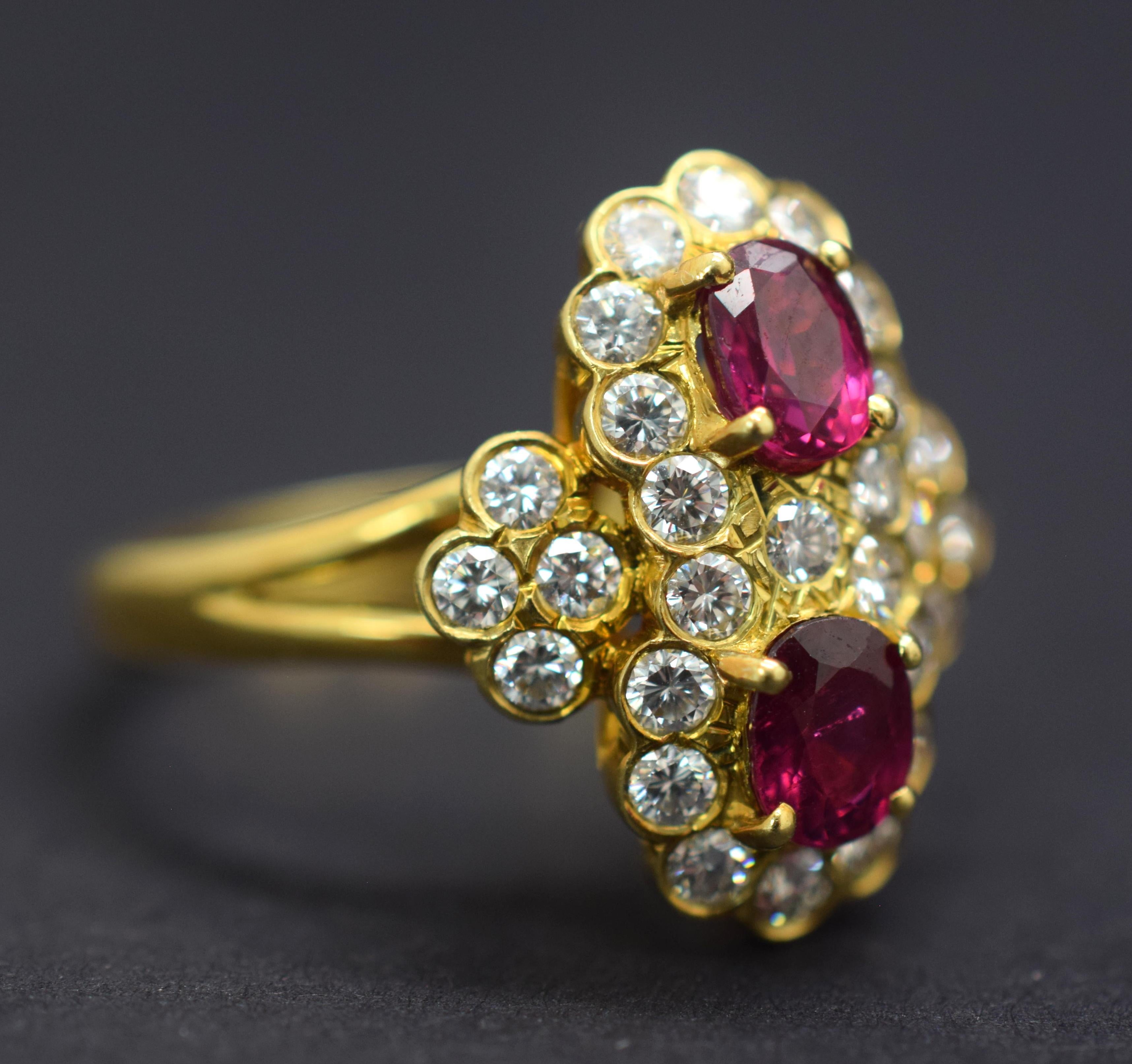Gorgeous Ruby and Diamond ring crafted in 18k yellow gold.  This split shank ring is truly a estate masterpiece.  The focal point of the ring are two oval cut Ruby gemstones displaying vivid purplish red color and high end clarity. Each Ruby weighs