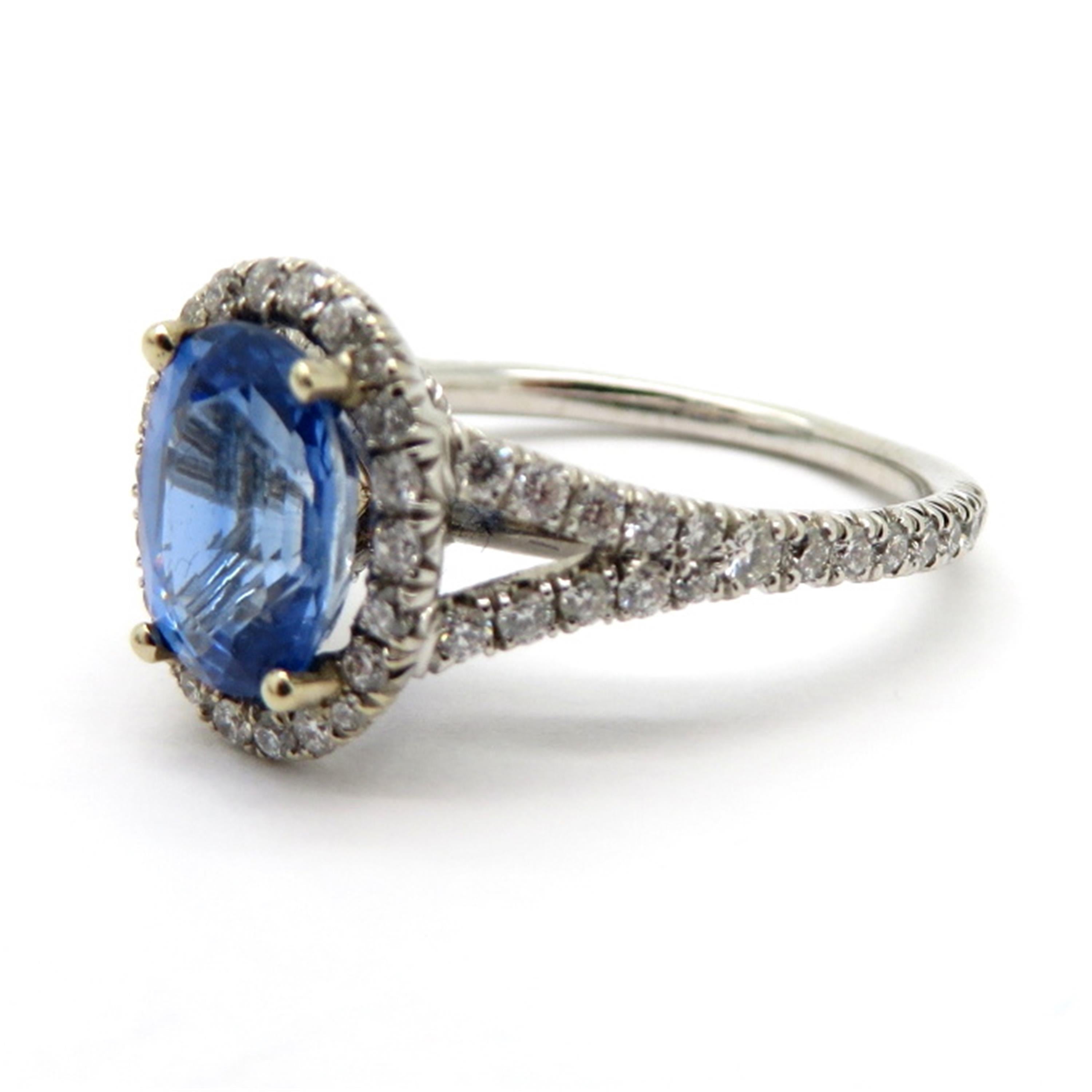 Estate sapphire and diamond 18K white gold halo ring. Centering one oval brilliant cut ceylon blue sapphire weighing approximately 1.47 carats. Interspersed with 74 round brilliant cut diamonds weighing a combined total of approximately 0.50 carats.