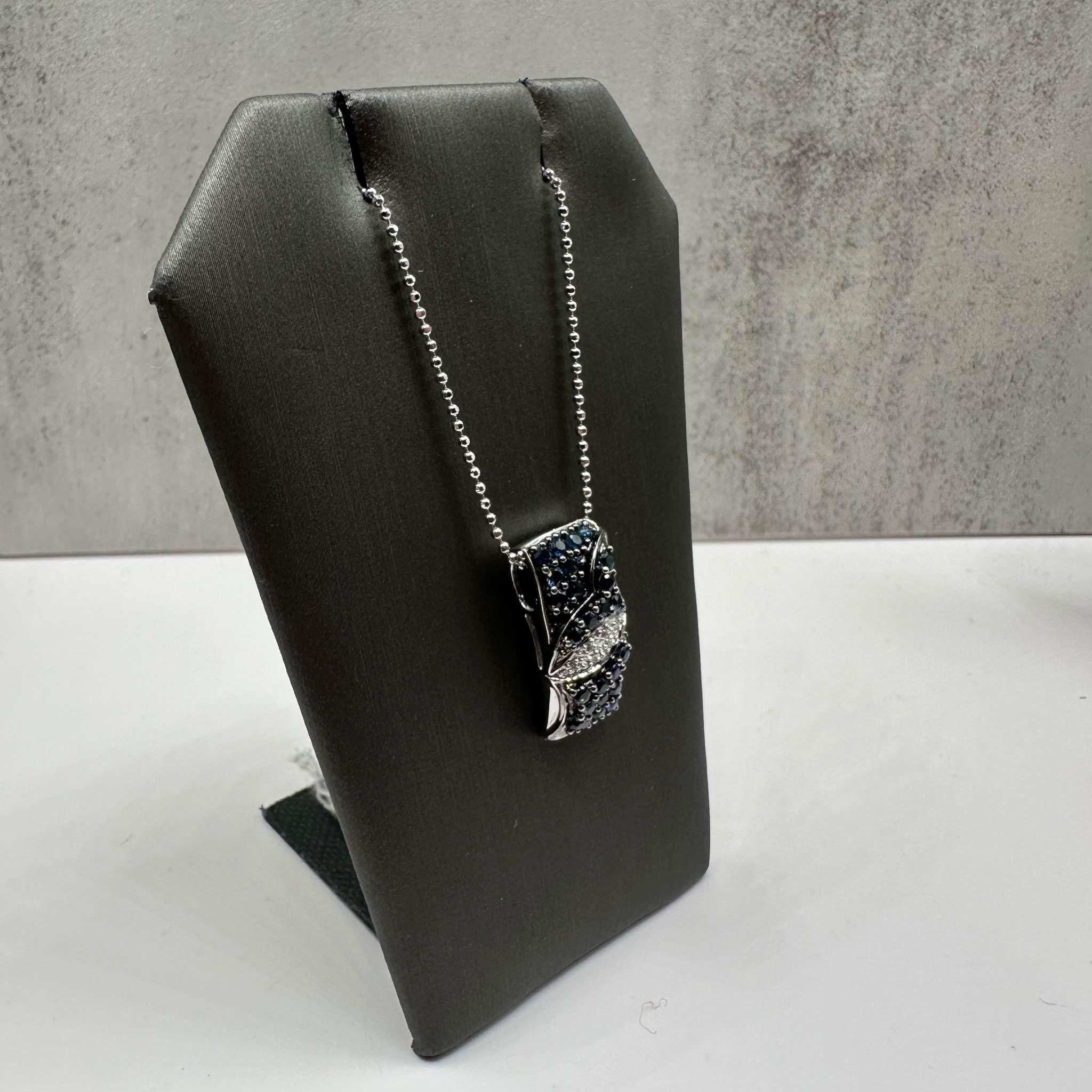This stunning Estate Sapphire and Diamond Necklace features approximately 1ctw of round blue sapphires, beautifully complemented by approximately 0.03ctw of natural GH I1 round diamonds for added sparkle. The pendant is crafted in 18kt white gold,
