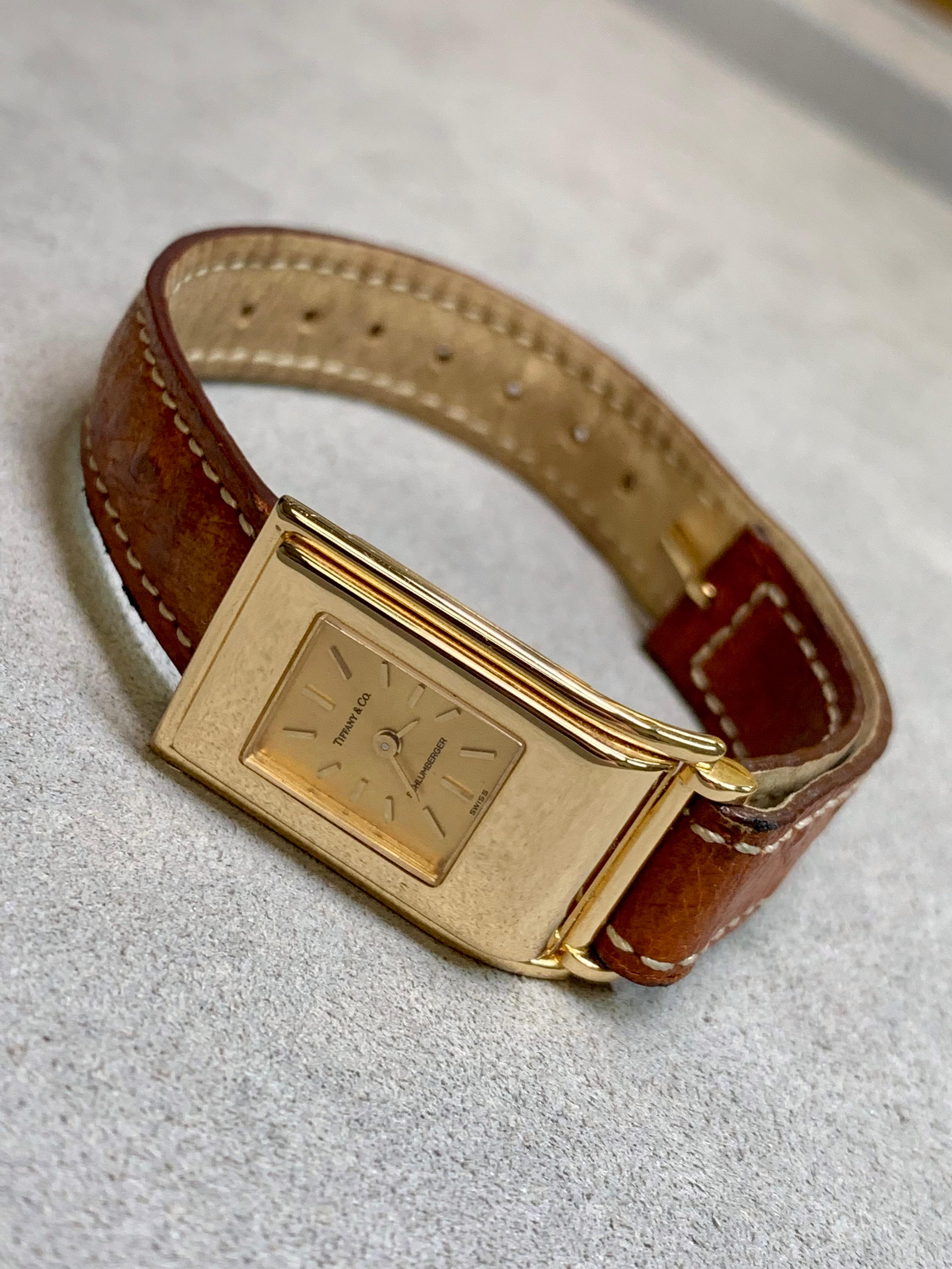 Eine original Schlumberger für Tiffany & Co. Damenuhr in 18K Gelbgold mit Quarzwerk. Es kommt mit einem zuvor genossen braunen Lederband sowie ein stark abgenutzten schwarzen Lederband. Der Verkauf dieser Uhr wird von den Originalschachteln und