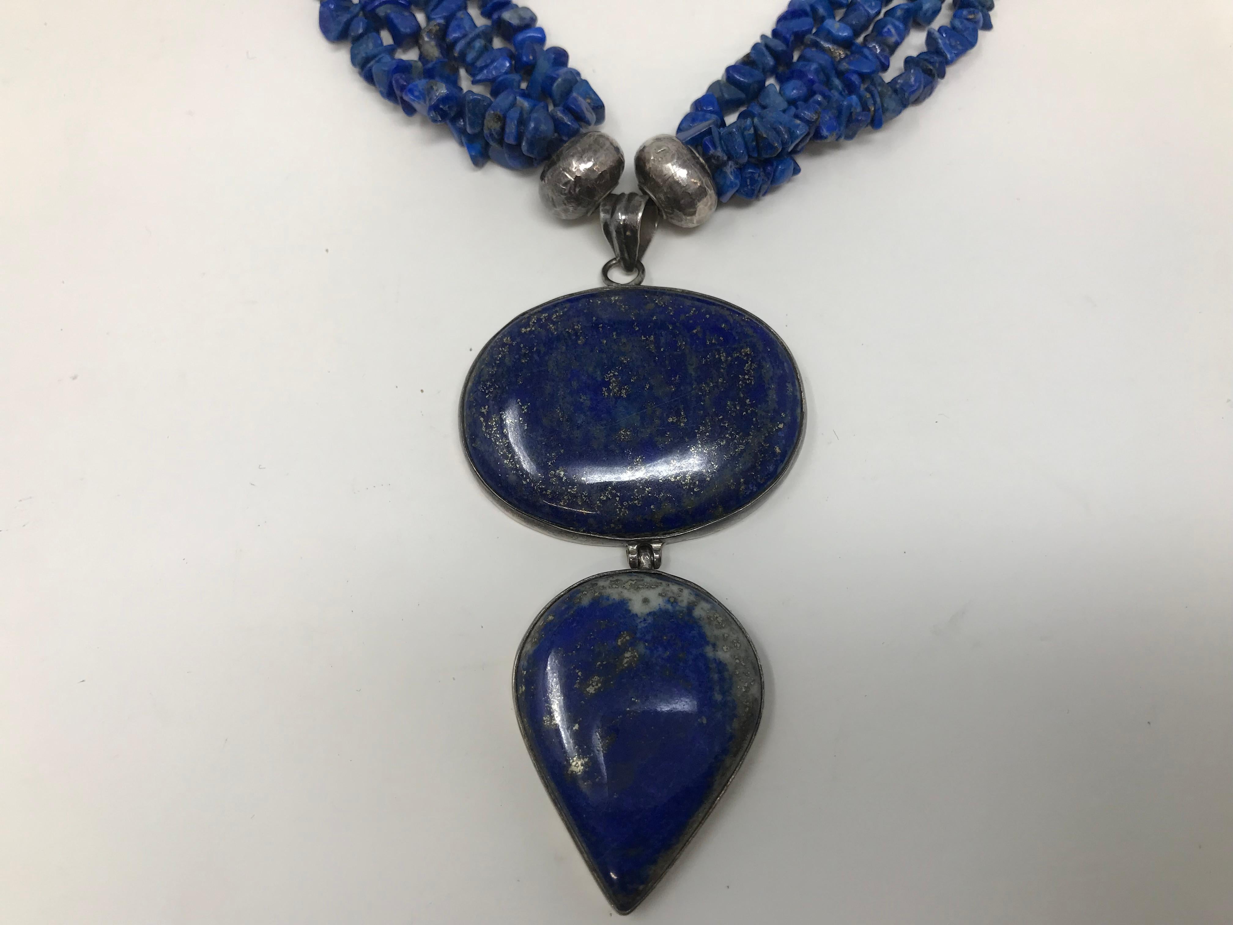 Estate four strand necklace, with chunky lapis lazuli stones and double pendants on silver mount. The necklace measures 17 1/2 inches  plus the two pendants 3 inches. In good condition.