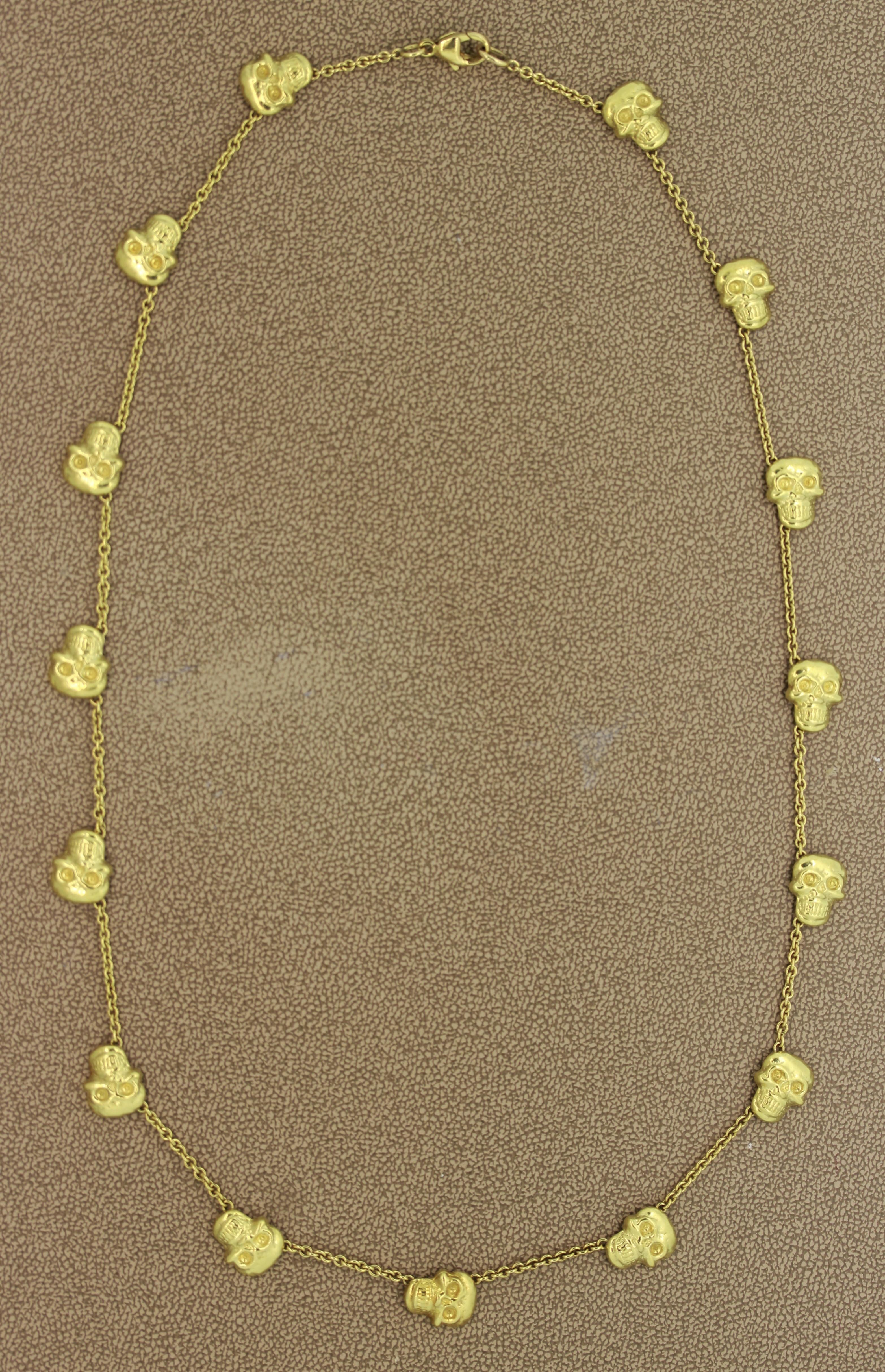 An 18k gold necklace featuring 15 handmade skulls set along the chain. The necklace is 20 inches long.