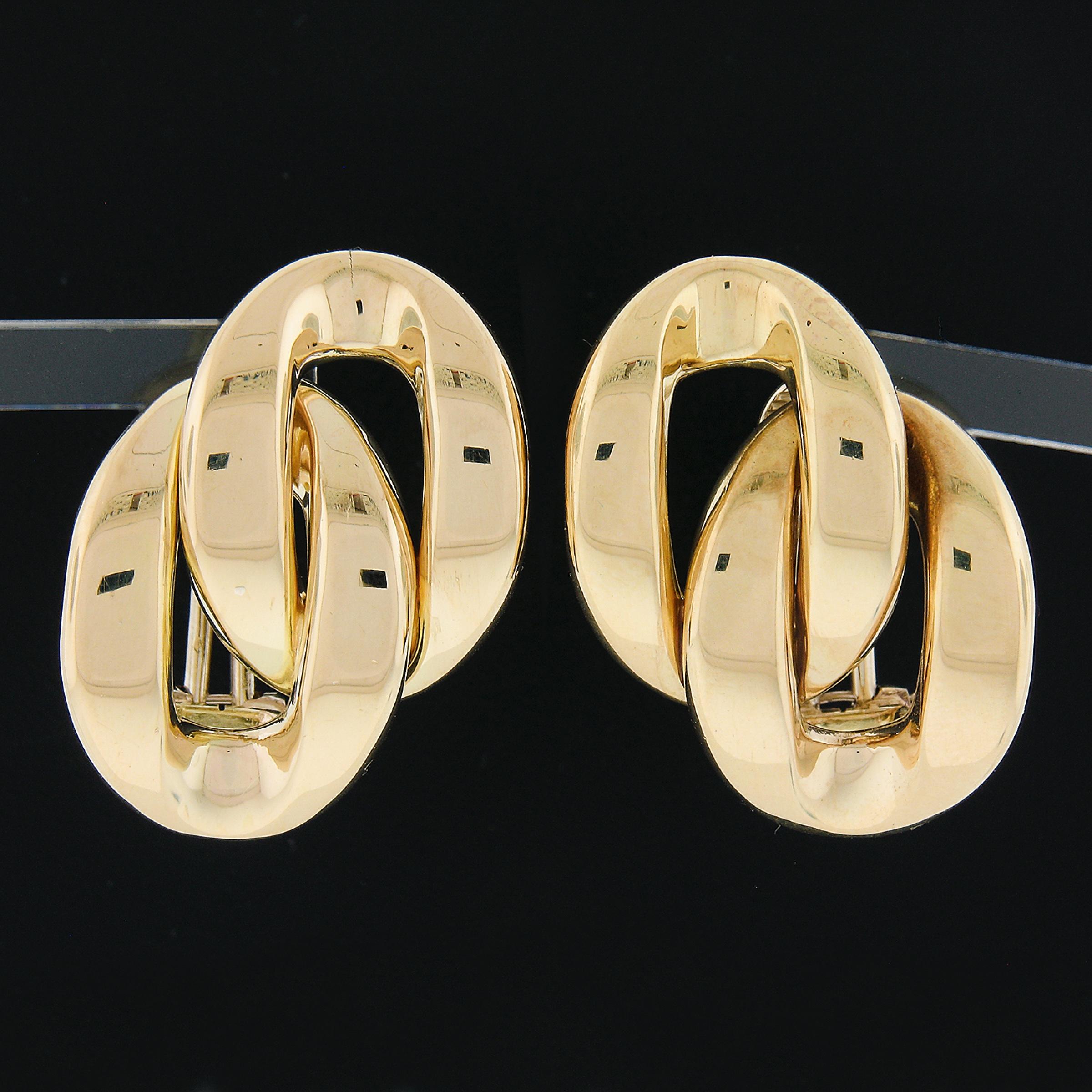 You are looking at a very beautiful pair of solid 18k yellow gold earrings. The earrings feature an interlocking curb design combining two polished slightly puffed oval shaped. These simple earrings are solidly constructed with tight and secure post