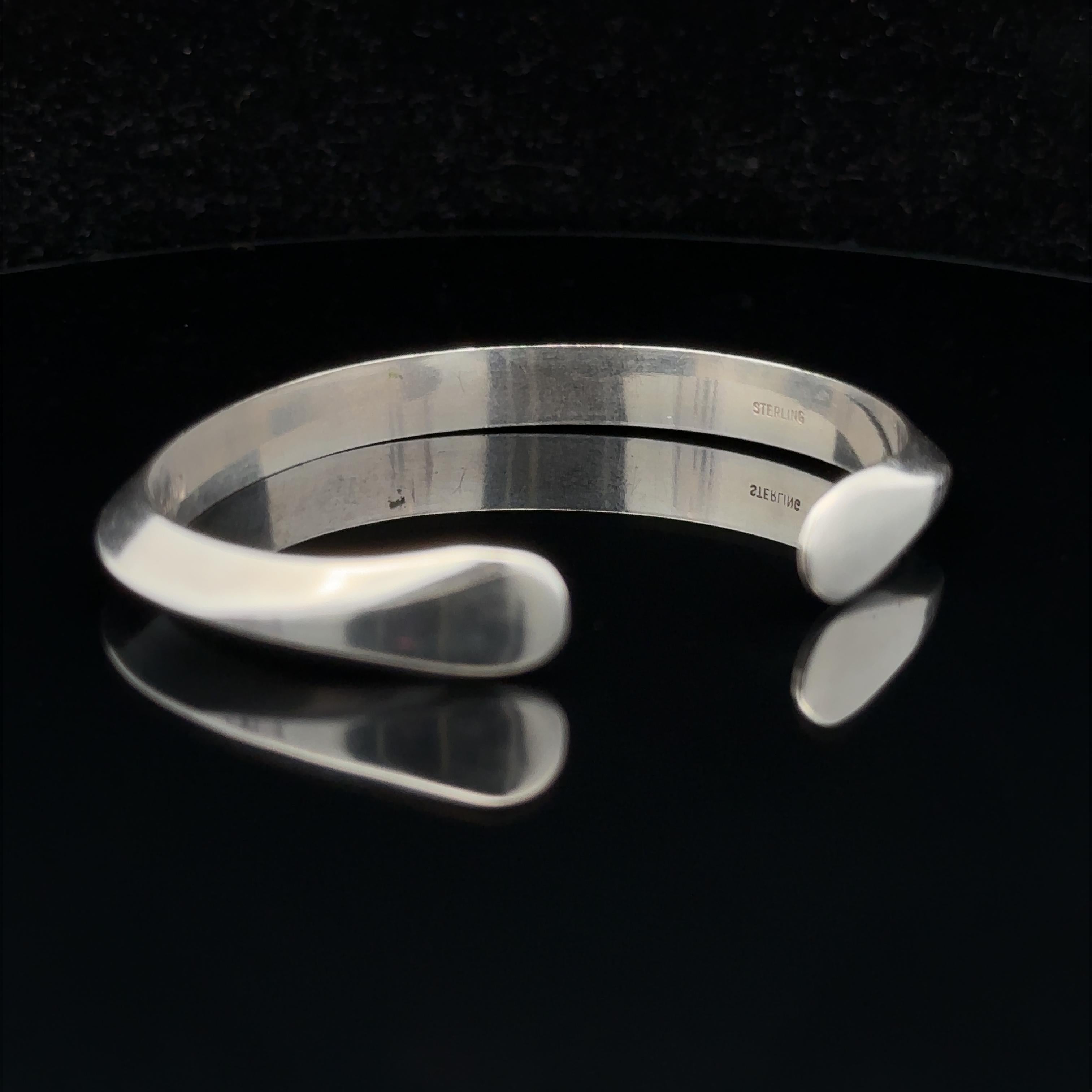 Material: Sterling Silver .925
Weight: 23.20 Grams
Type: Knife Edge - Open Cuff Bangle 
Length: Will comfortably fit up to 6” wrist (fitted on wrist)
Width: 6.8mm (0.26”) (approx.)
Thickness: 3.95mm rise off wrist
Condition: Signed SMD. Original