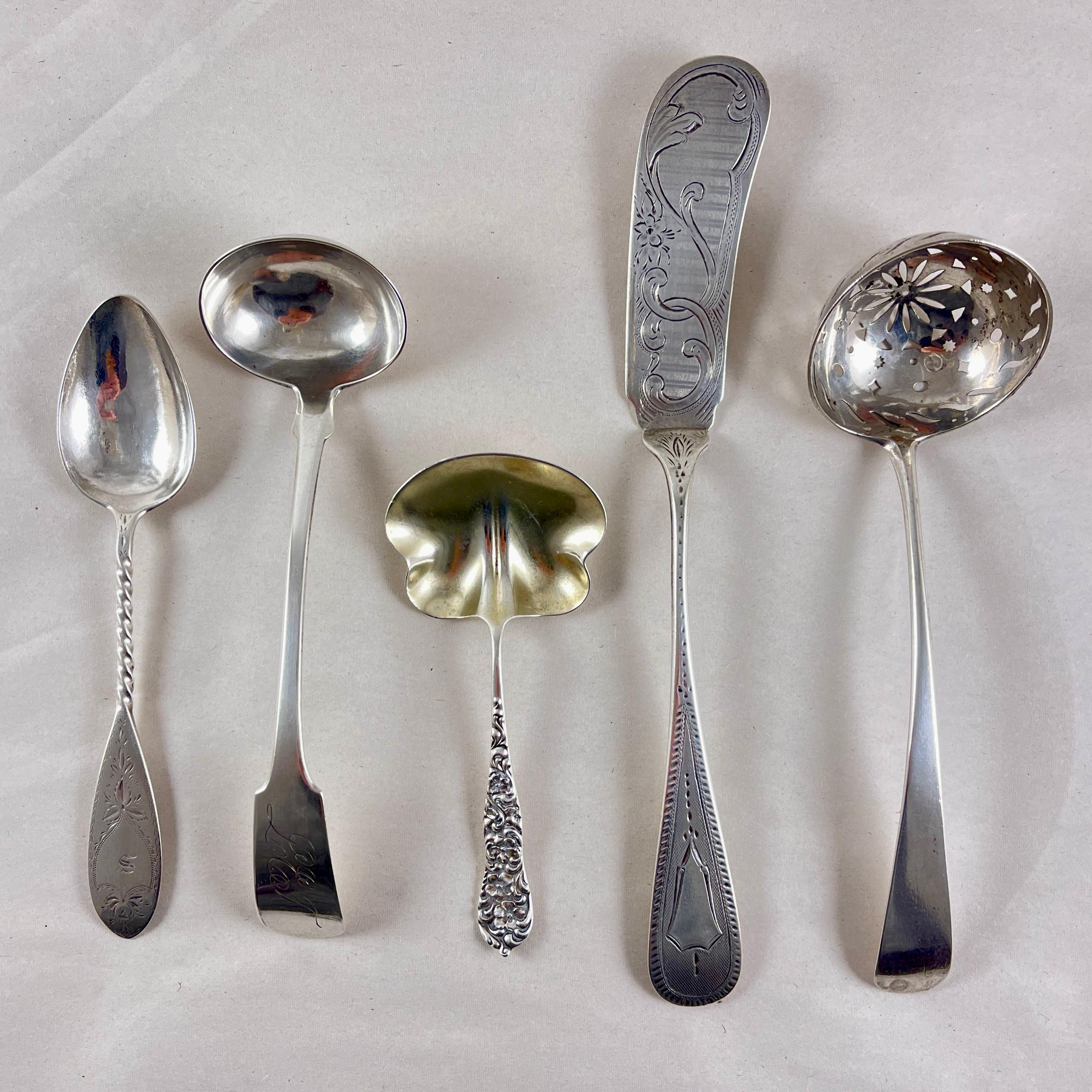 A mixed group of five, estate American sterling silver serving pieces, all dating to the mid-late 19th Century.

Long Handled Spreader – bright-cut engraving. Bailey & Company. 
8 inches L x 1 inches W

Pierced Ladle – Geometric pierced bowl, fiddle