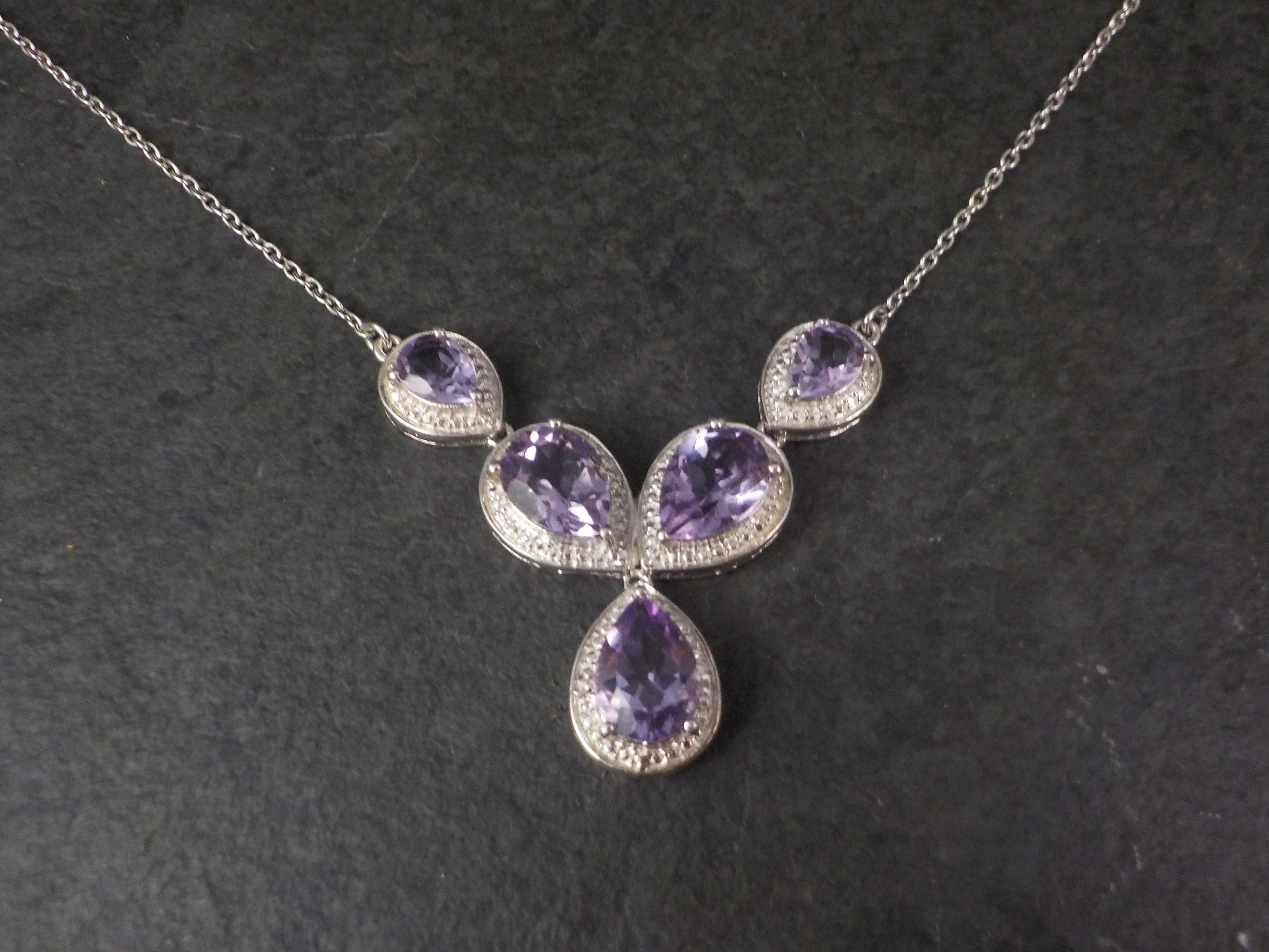 This beautiful necklace is sterling silver.
It features 5 pear cut amethysts measuring 7x9 and 5x7mm.

This necklace measures 19 1/2 inches from end to end and 10 1/2 inches when clasped from clasp to bottom of the longest drop.
Weight: 7.6