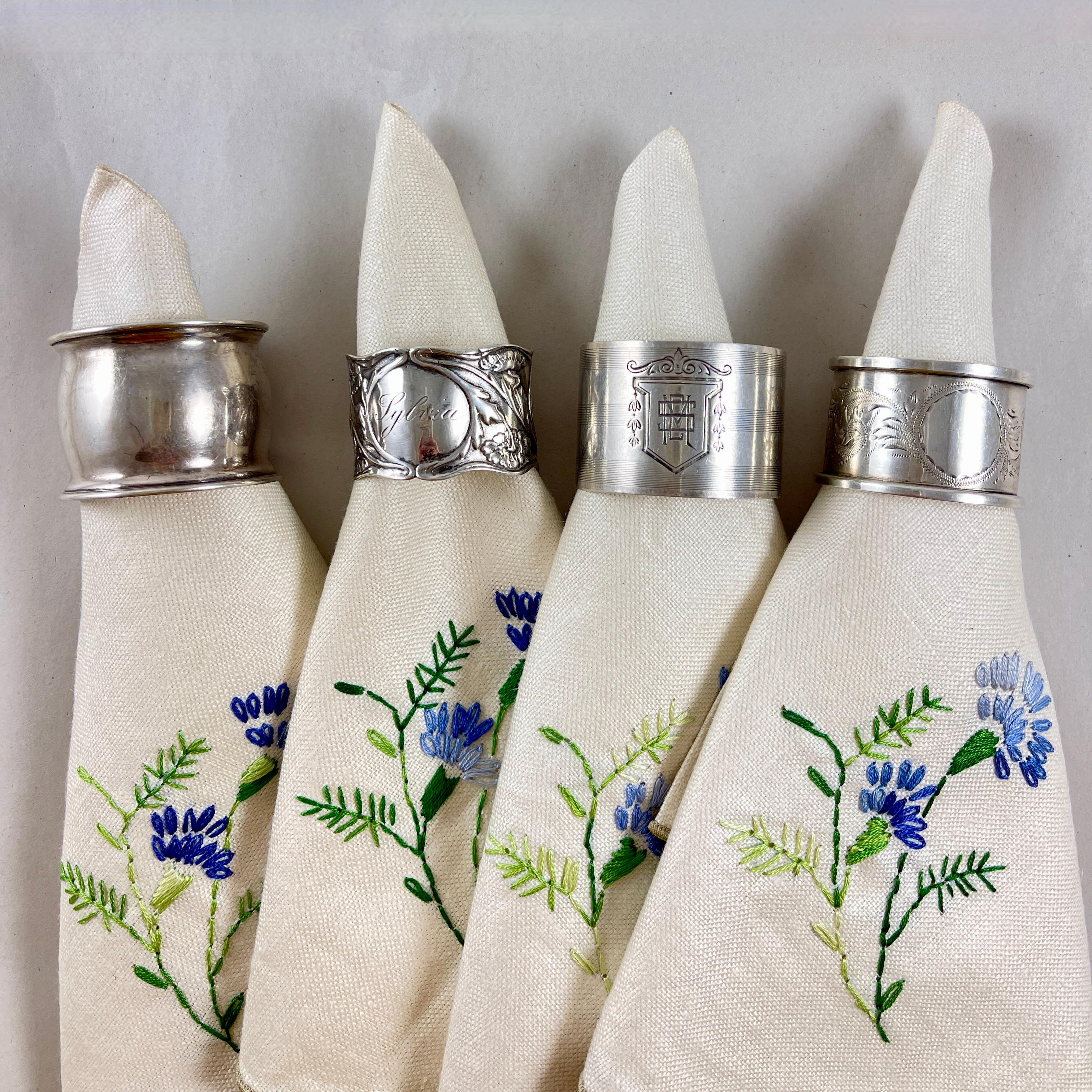 Ensemble de quatre ronds de serviette vintage en argent sterling à large bande, de différents fabricants, vers les années 1920-1930.

Merveilleux exemples :
Une bague est gravée du nom 