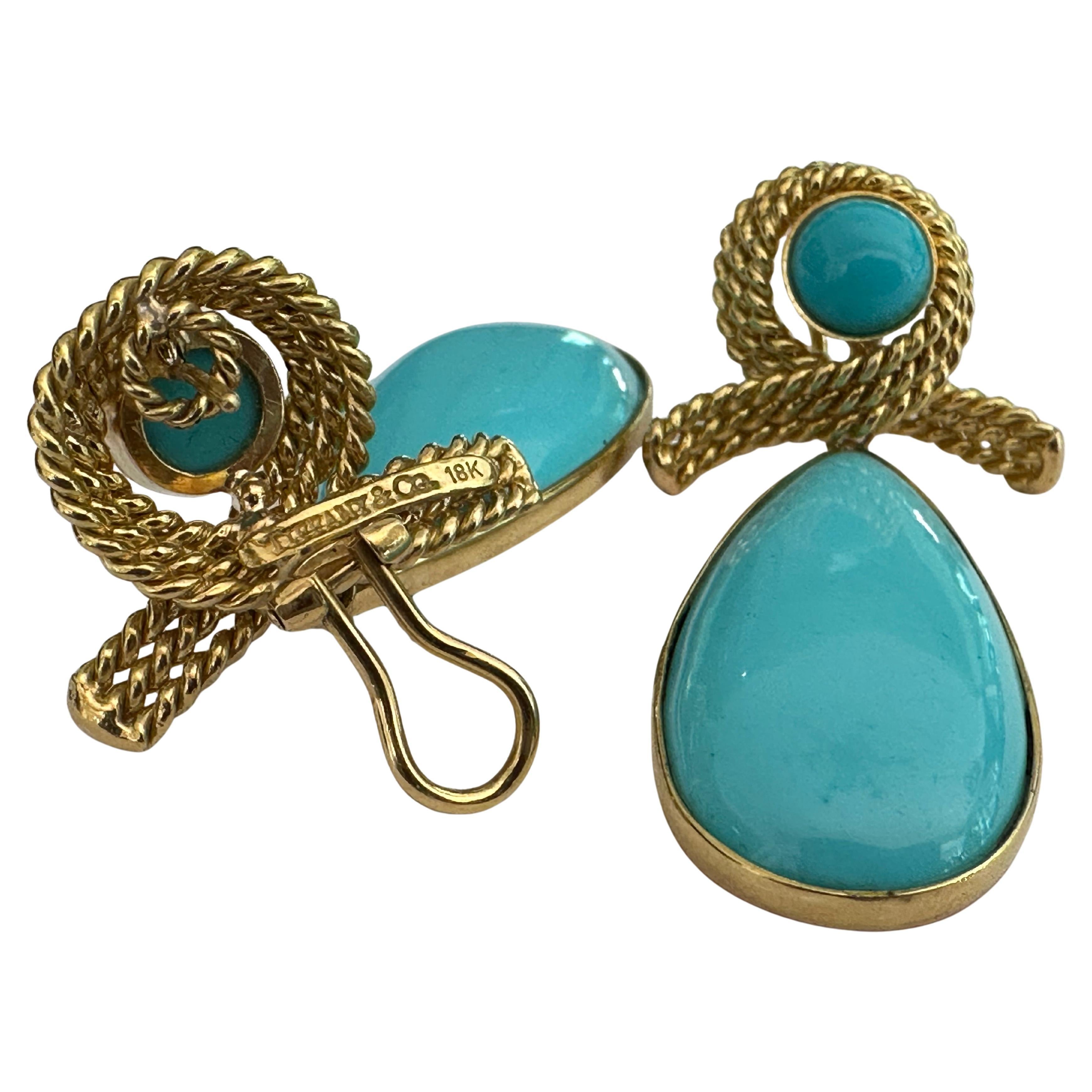 Ces boucles d'oreilles vintage Tiffany and Co présentent un motif de corde croisée en or jaune 18 carats qui encercle un cabochon de turquoise rond attaché à un cabochon de turquoise plus grand en forme de goutte d'eau. Estampillé Tiffany & Co 18K.