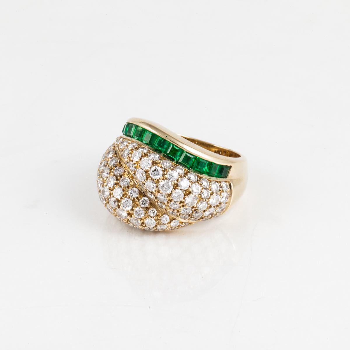 An estate Tiffany & Co. pavé diamond dome ring with square-cut emerald accents in 18K yellow gold.  The ring has 113 round diamonds that total 4.50 carats, E-F color and VVS2-VS1 clarity.  The ring is currently a size 6 3/4 and is sizeable.  London,