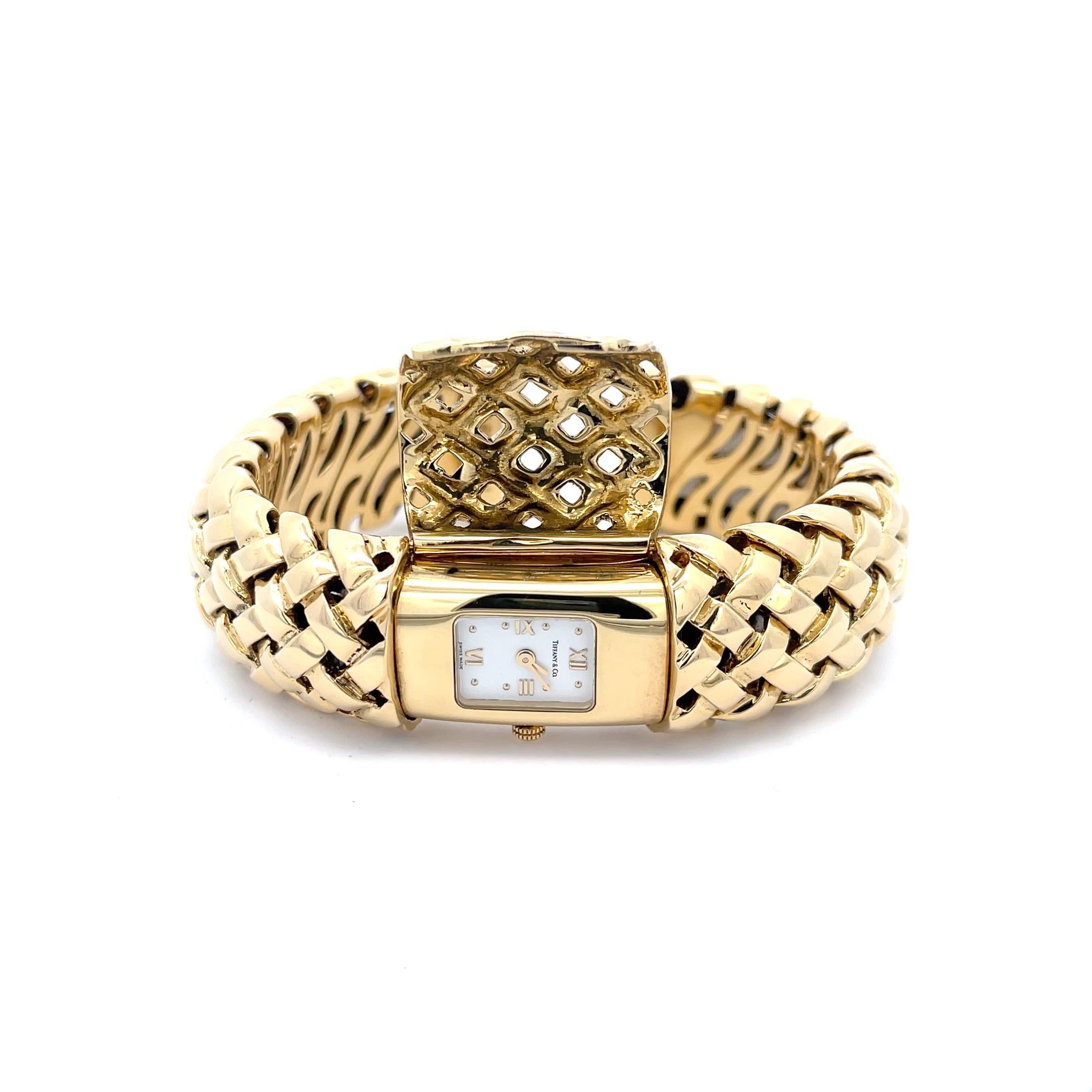 Nachlass Tiffany & Co. Manschettenarmband mit verstecktem Zifferblatt aus 18 Karat Gold. Die Manschette weist ein schönes gewebtes Muster mit einem versteckten Ziffernblatt in der Mitte auf. Ca. 1996. Die Manschette wiegt 123,8 Gramm und ist 3/4