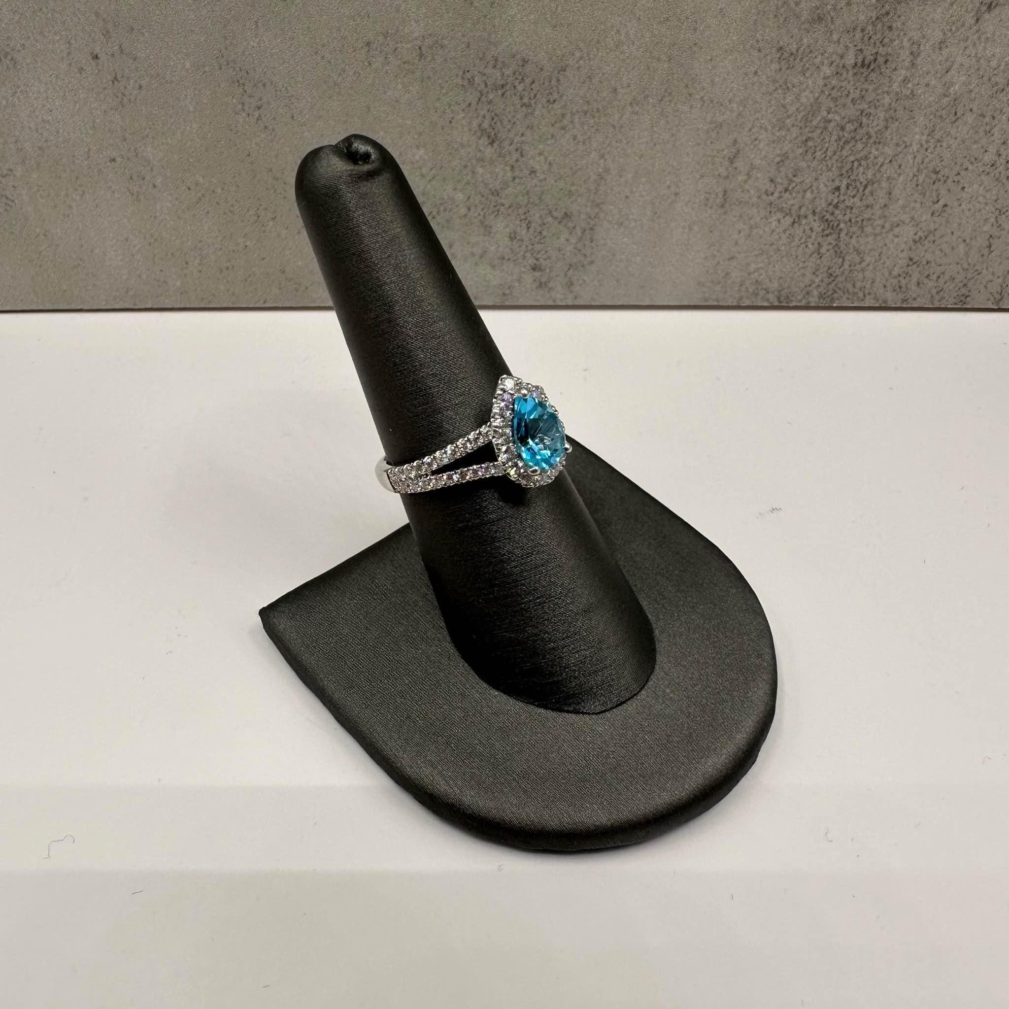 Este impresionante anillo de la finca cuenta con un hermoso topacio talla pera de 8,5 x 6 mm engastado en lujoso oro blanco de 14 quilates. Alrededor del topacio hay aproximadamente 0,75 ctw de diamantes redondos naturales de color GH y claridad SI,
