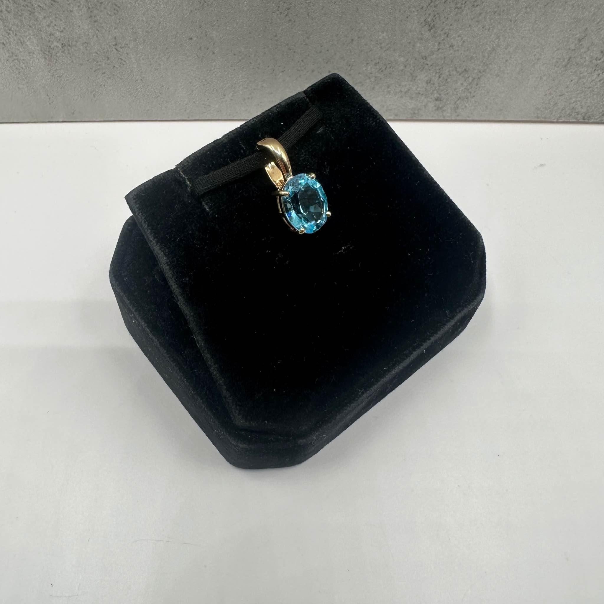 This stunning Estate Topaz Pendant/Necklace Enhancer in 14kt yellow gold features an 11x9mm oval blue topaz, offering vibrant color and elegance. Weighing 2.4 grams, it provides a comfortable, substantial feel. The bail has inside dimensions of