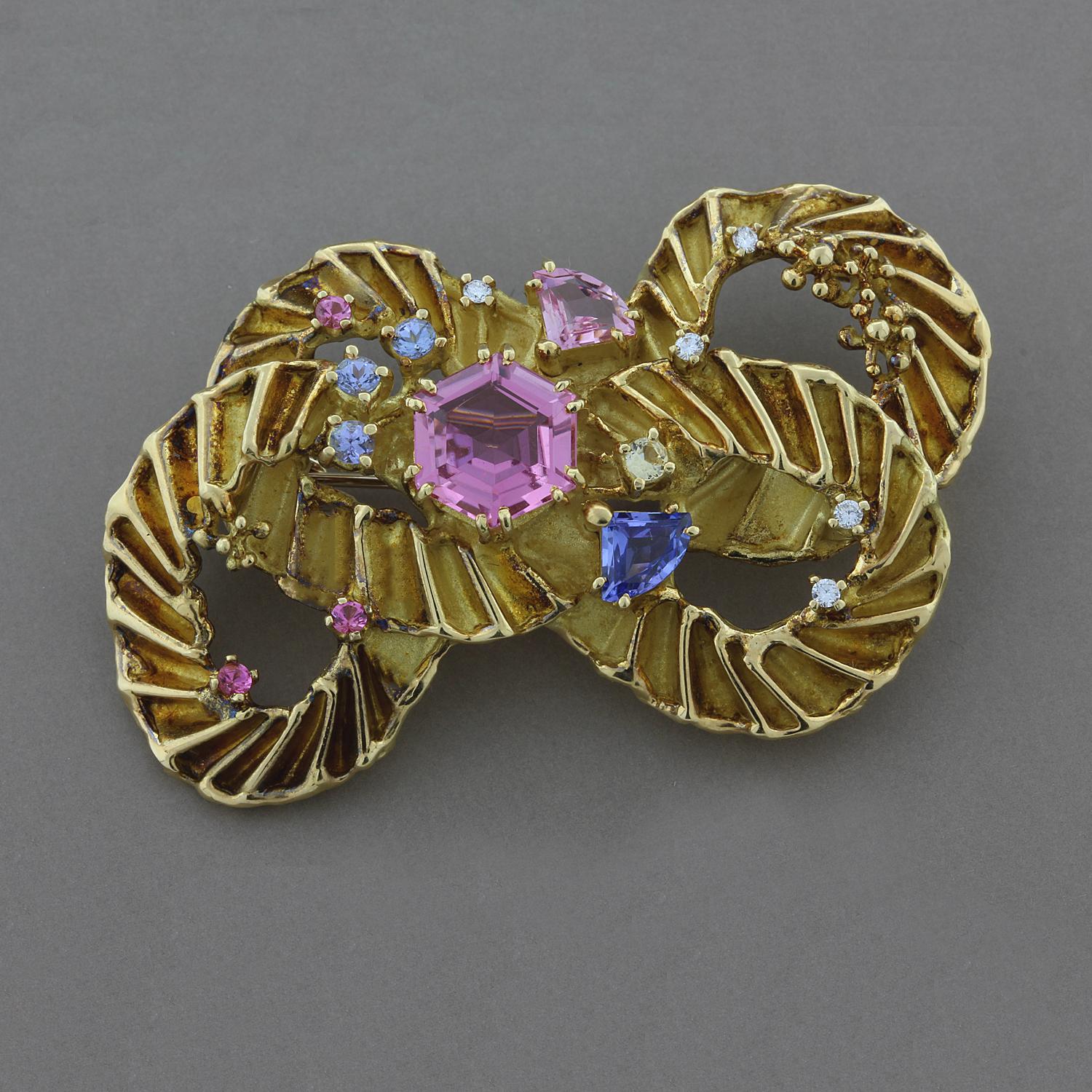 A one of a kind brooch features 2.62 carats of tourmaline and 0.11 carats of round brilliant cut diamonds. The tourmaline range in a soft pink color to a blue/violet which all complement each other. The gems and diamonds are set in 18K yellow gold